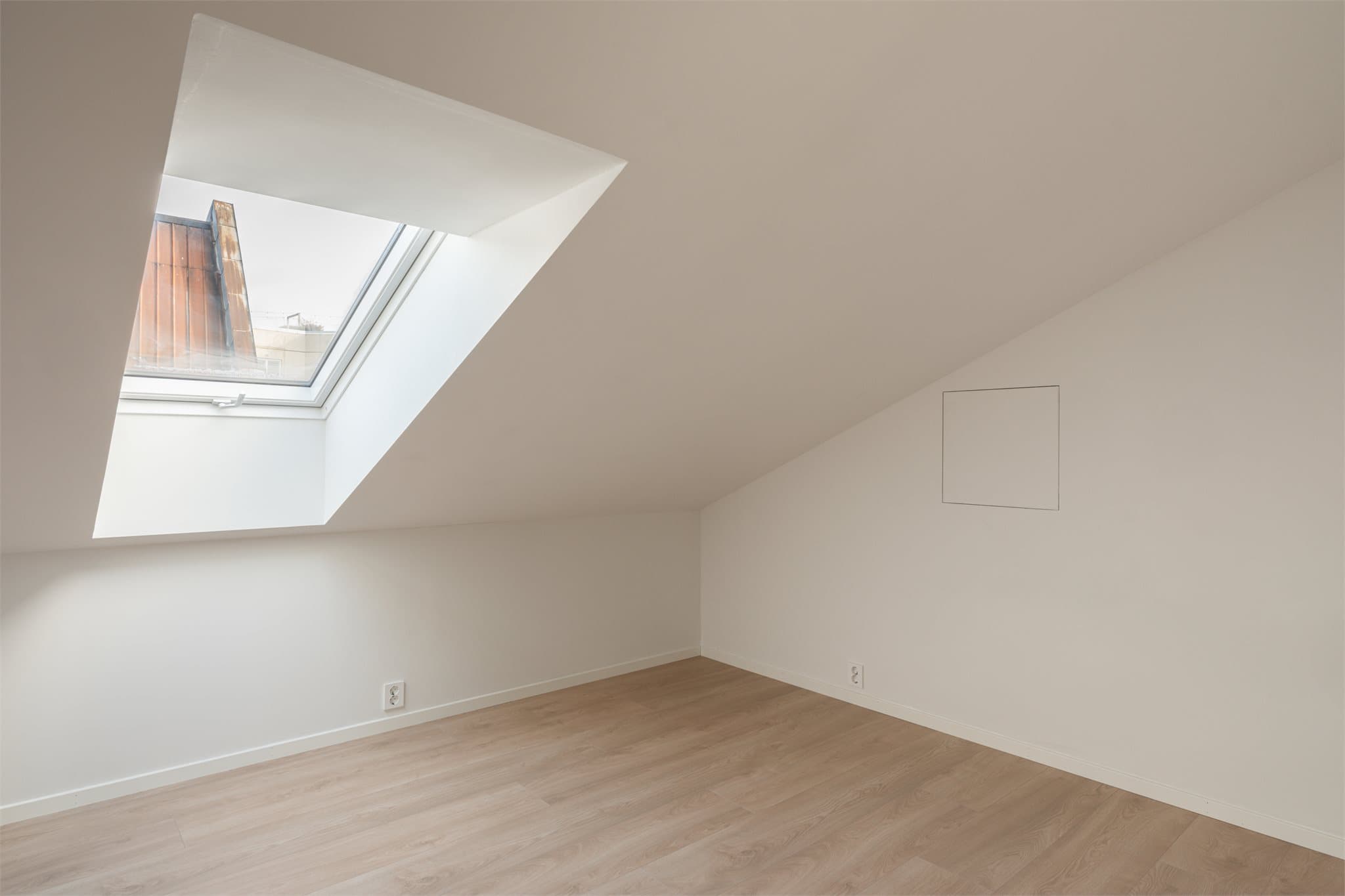 Lyst og innbydende soverom med takvindu som gir godt med naturlig lys.