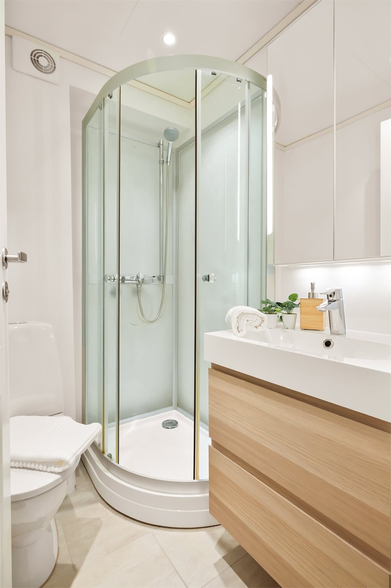 - Badet er innredet med laminerte fronter, heldekkende servant, speilskap med belysning, gulvstående toalett og dusjkabinett -