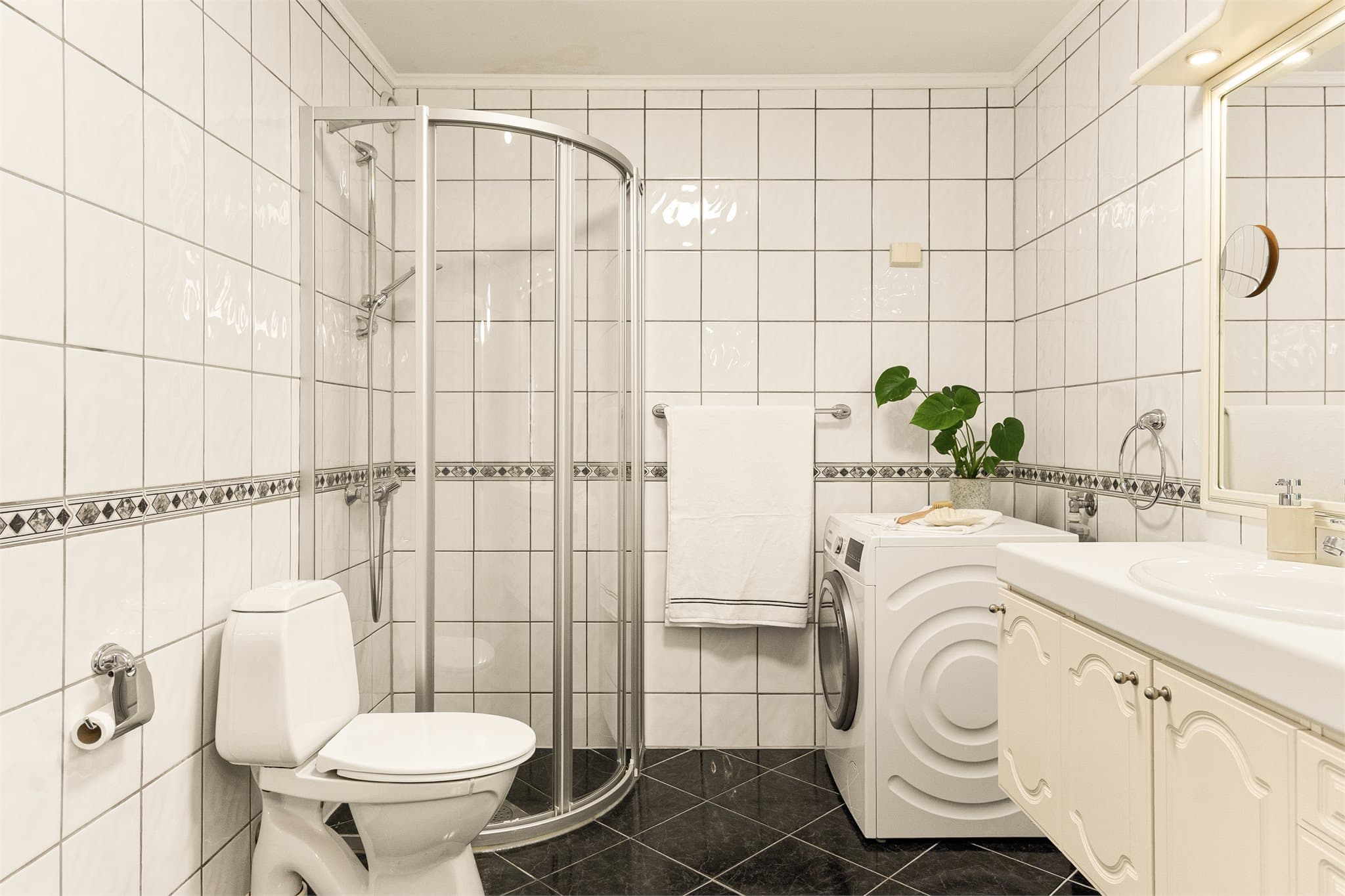- Badet måler 5,7 m² og har fliser på gulv og vegger -