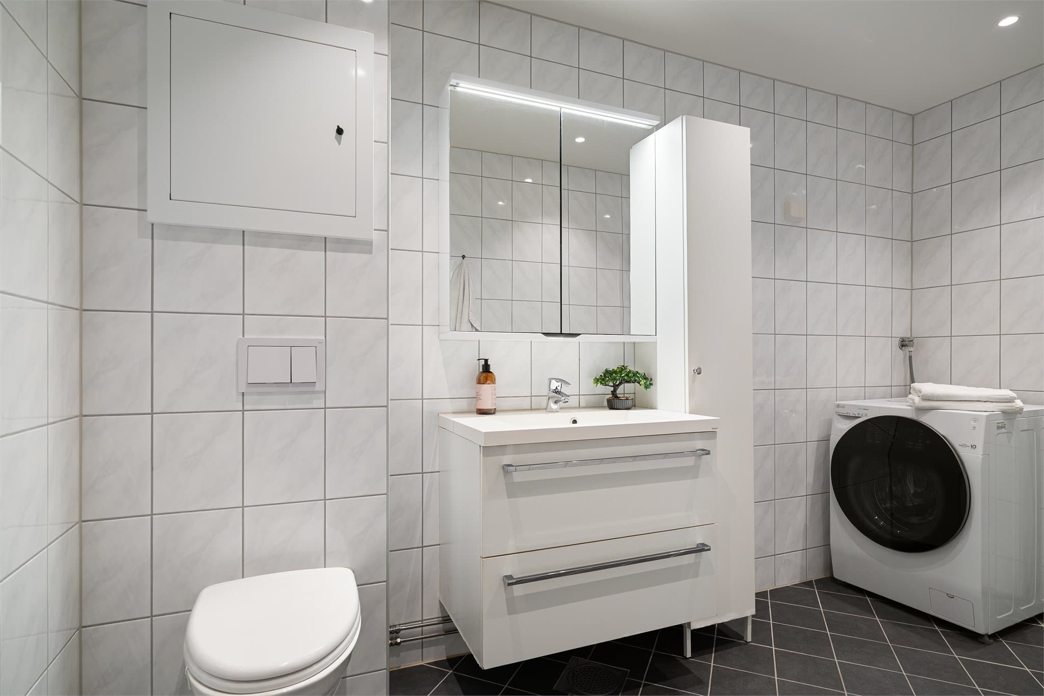 Pent og flislagt bad fra 2019, med vegghengt toalett, god oppbevaring og opplegg for vaskemaskin