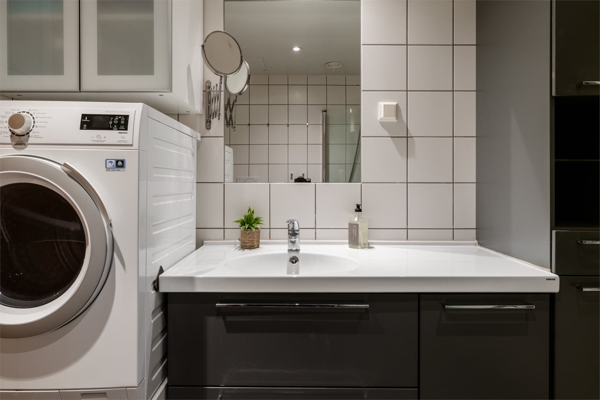 Praktisk baderomsinnredning med servant og opplegg for vaskemaskin