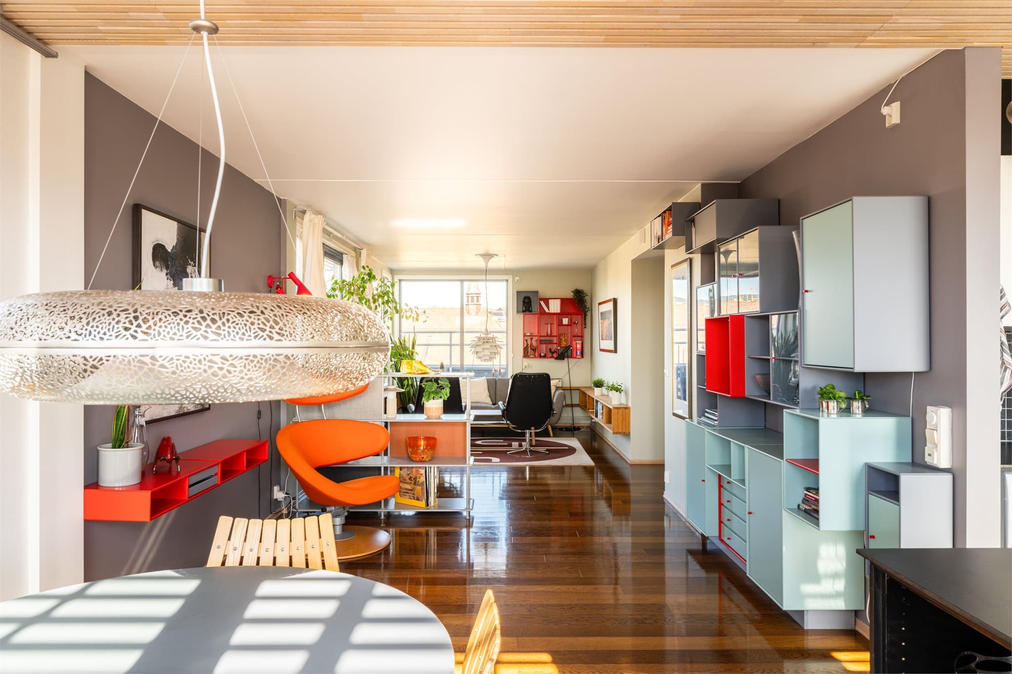 Et lyst og luftig oppholdsrom som strekker seg gjennom leiligheten.