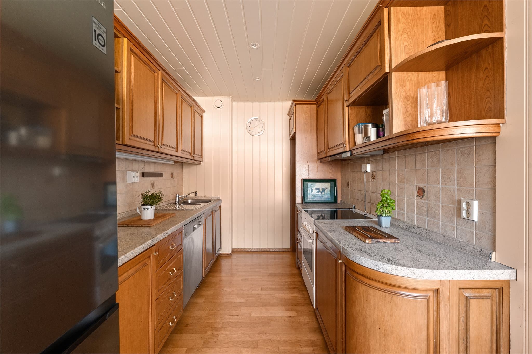 Innredningen har profilerte fronter i trevirke og laminat benkeplate med nedfelt oppvaskkum i rustfritt stål.