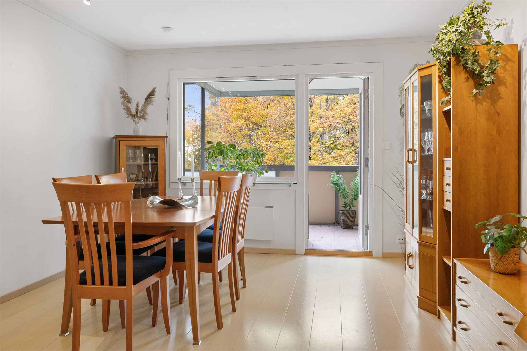 Stuen fremstår som lys og romslig, med lyse vegger og 1-stavs parkettgulv som gir et moderne og helhetlig uttrykk. Fra stuen er det utgang til innglasset balkong med foldedører og overbygd balkong.