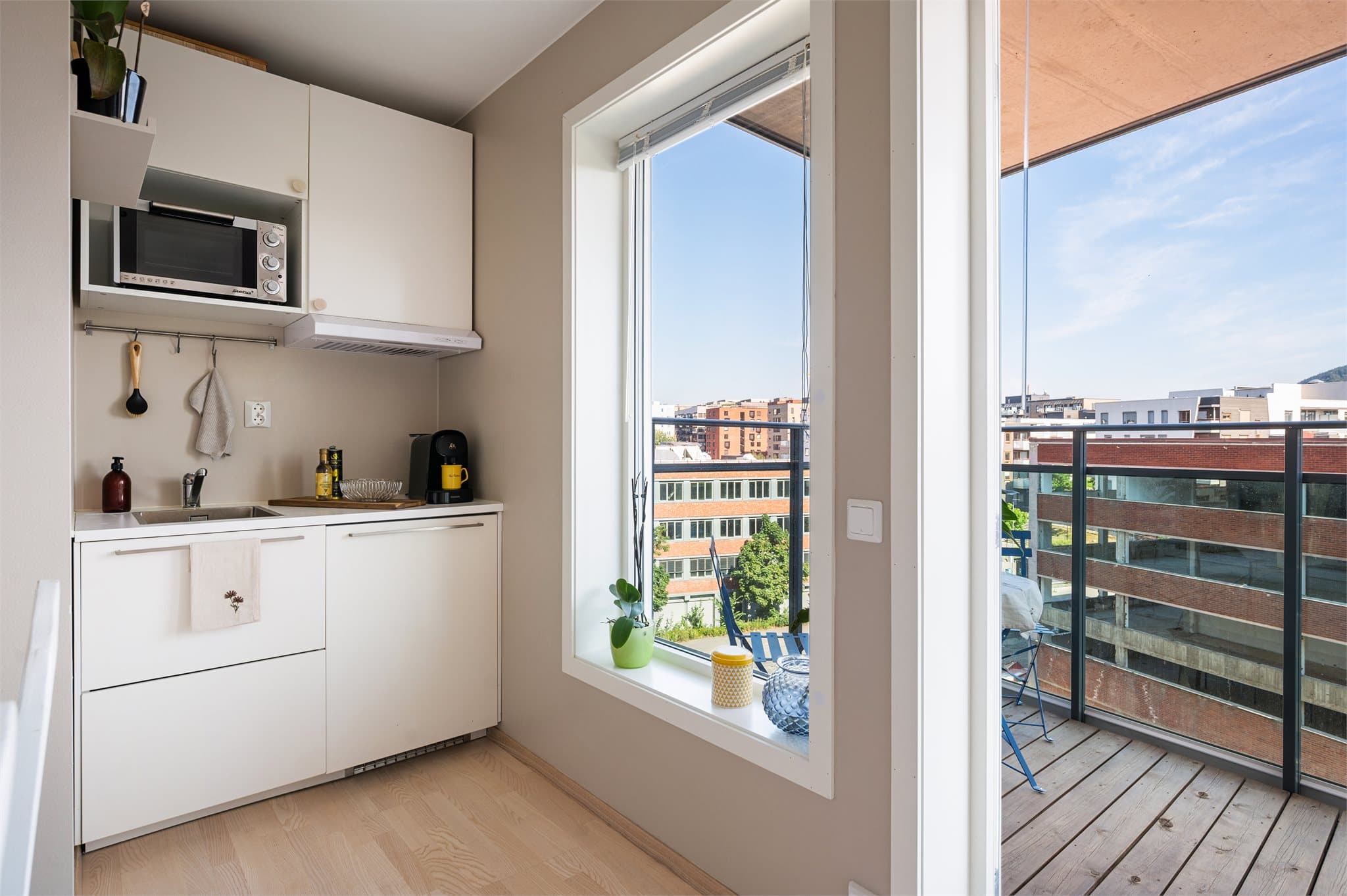 Hybelen har en kombinert stue- og kjøkkenløsning med laminatbenkeplate.