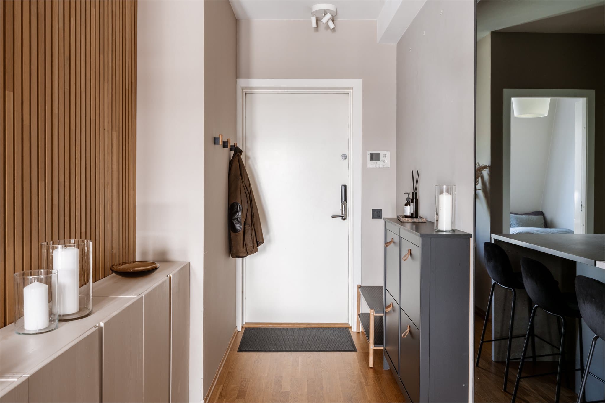 Entreen er lys og åpen, med plass sko og yttertøy, og leder inn mot kjøkken og oppholdsrom.