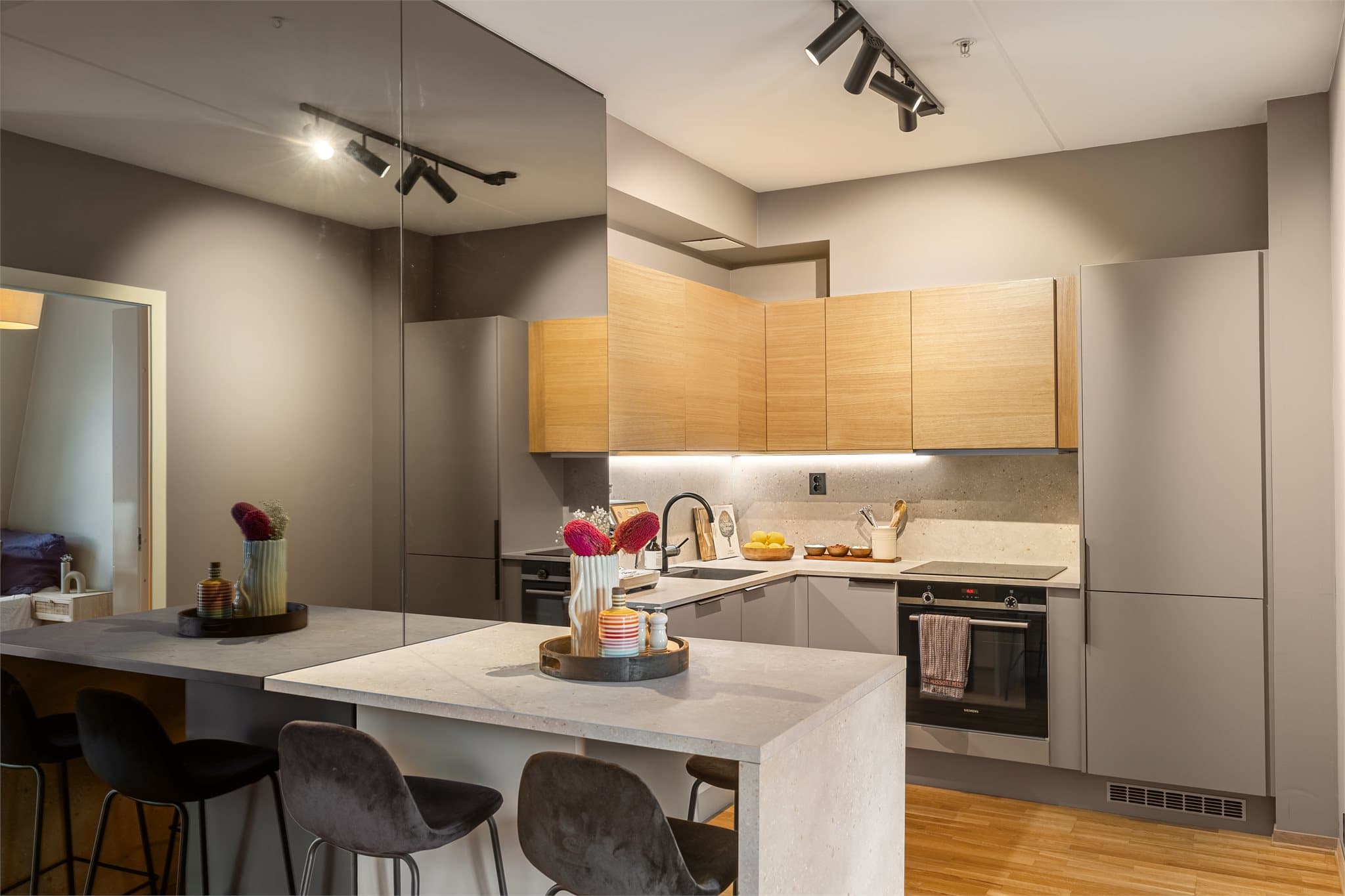 Den elegante sitteplassen skiller kjøkkenet fra entréen og stuen, og skaper en sosial møteplass.