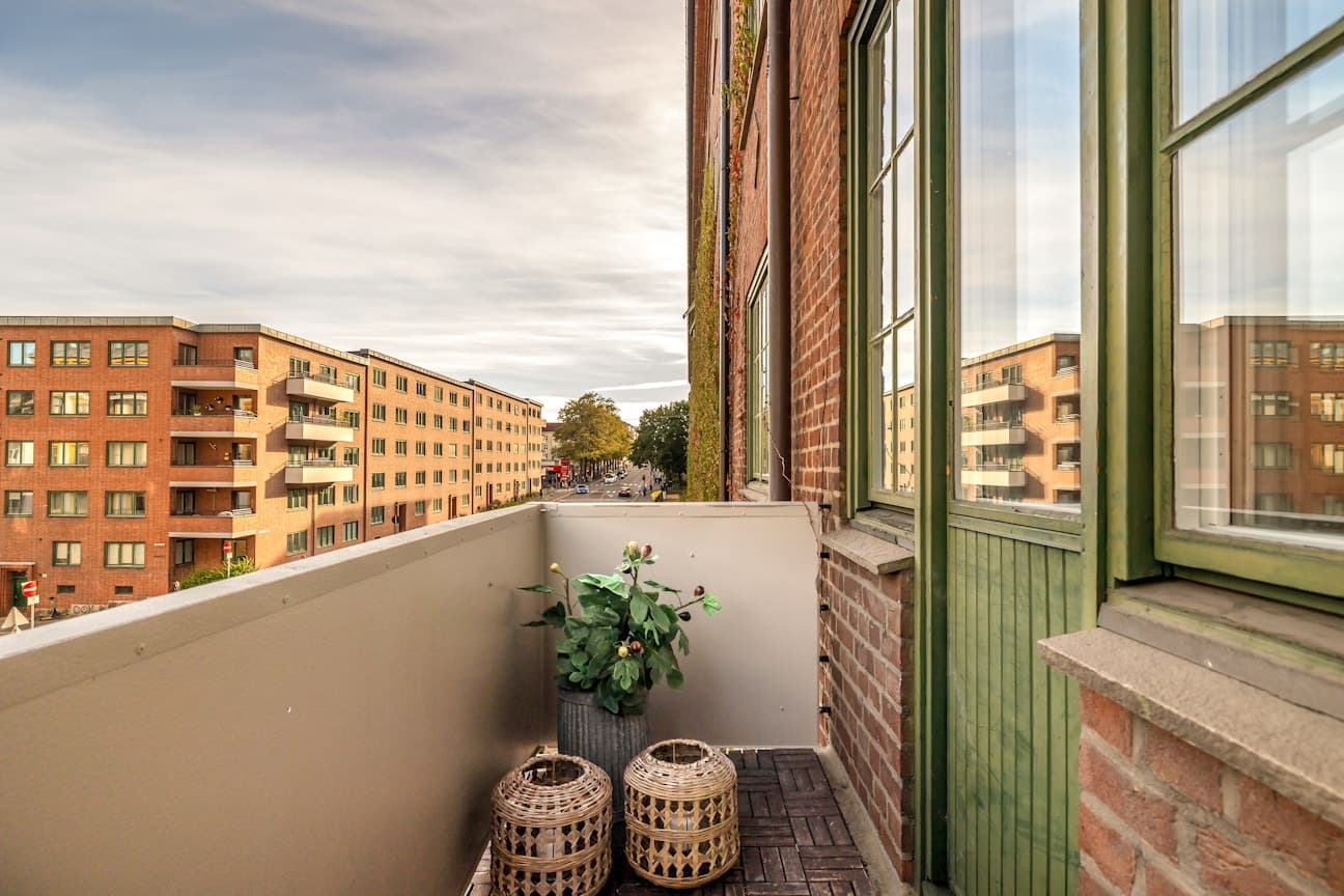 Lys og luftig hjørnebalkong med fritt utsyn – ideell for en hyggelig sittegruppe og frodige planter.