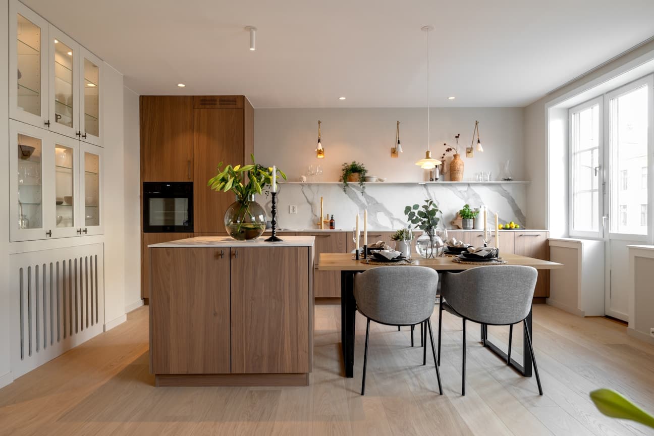 Kjøkkenet er nytt fra 2025 og fremstår som en elegant helhet med snekkertilpassede løsninger, moderne glatte fronter og en slitesterk kompositt benkeplate som kombinerer stil og funksjonalitet.