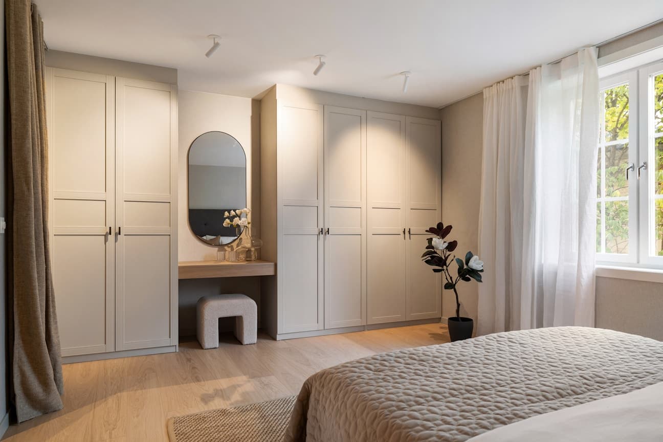Hovedsoverommet har plassbygd garderobeskap og sminkebord, samt tapet på vegg som gir et lunt preg.