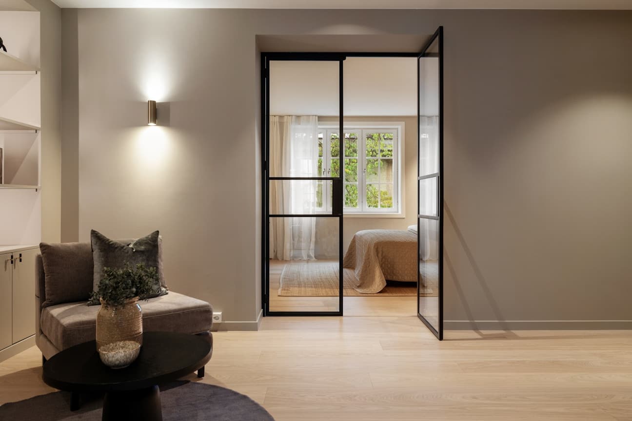 Hovedsoverommet ligger tilknyttet hallen. Glassdørene i leiligheten er lyddempende.