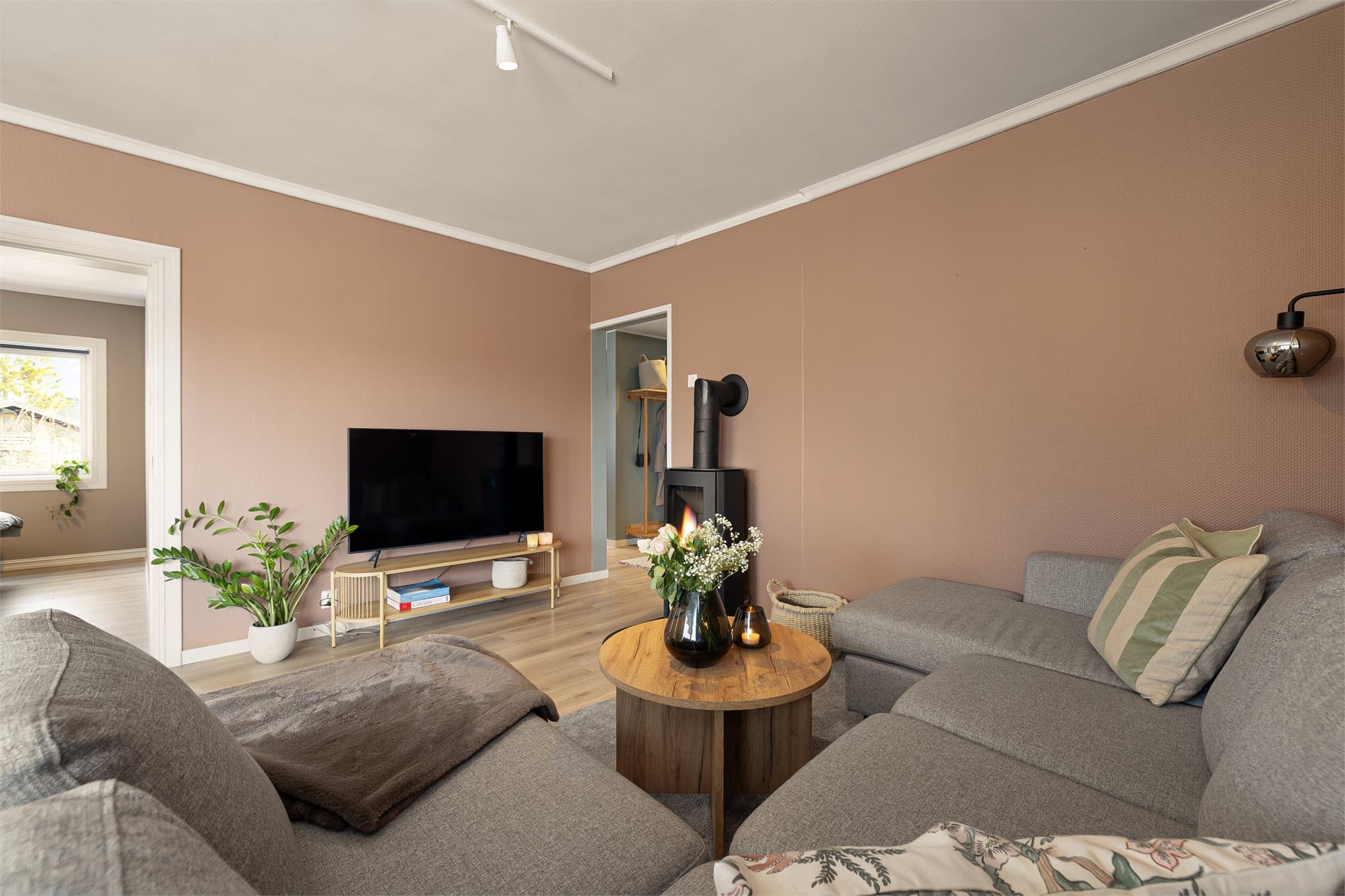 De varme tonene i stuen bidrar til et lunt og helhetlig uttrykk i oppholdsrommet.