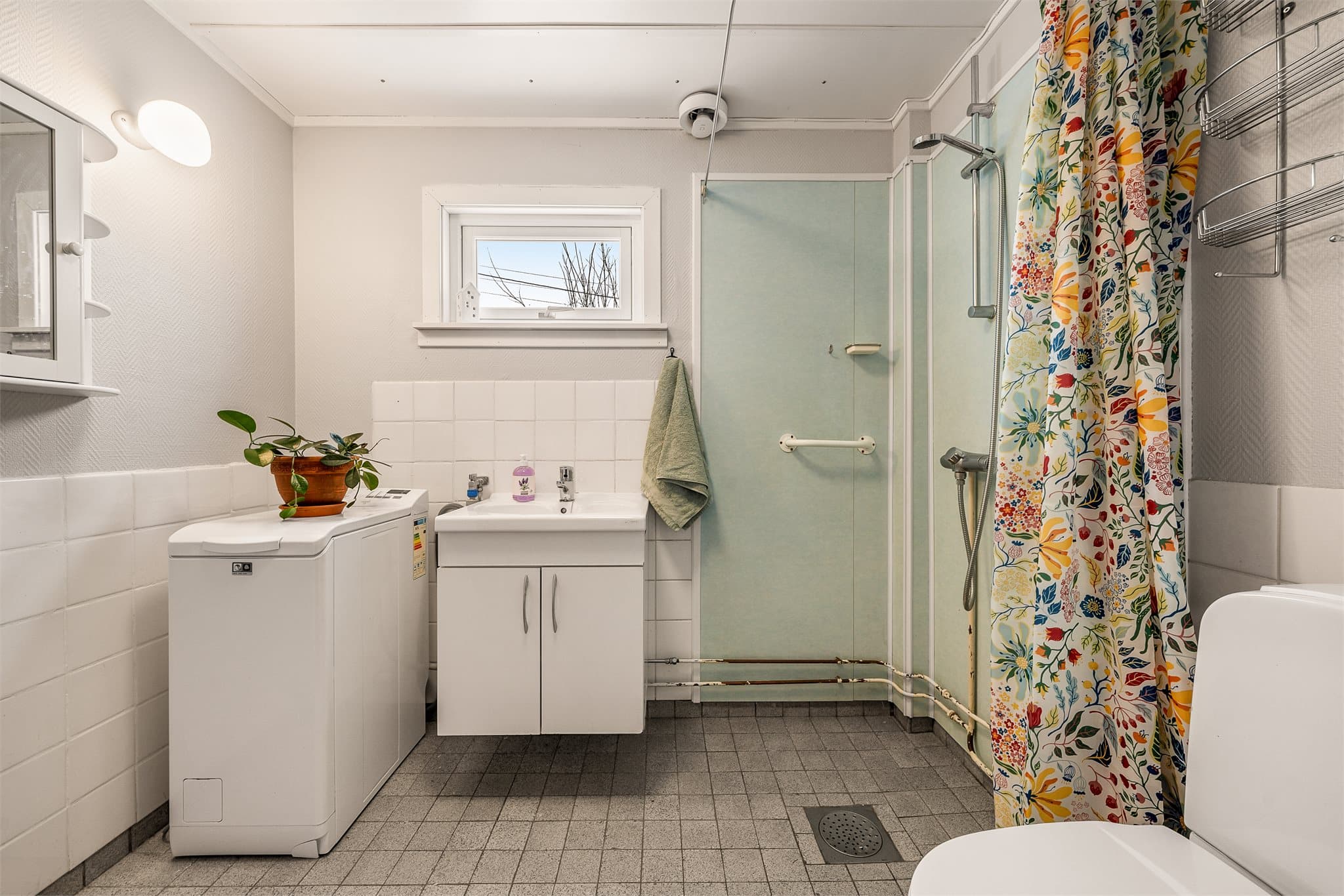 Bad har fliser på gulv og på vegg er det fliser og tapet.