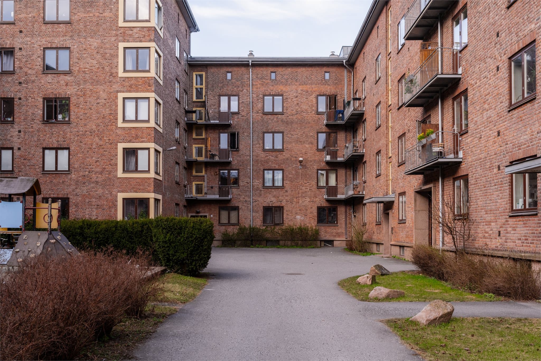 Den idylliske bakgården er pent opparbeidet med plen og beplanting. Det er flere sittegrupper og sykkelparkering for beboerne.