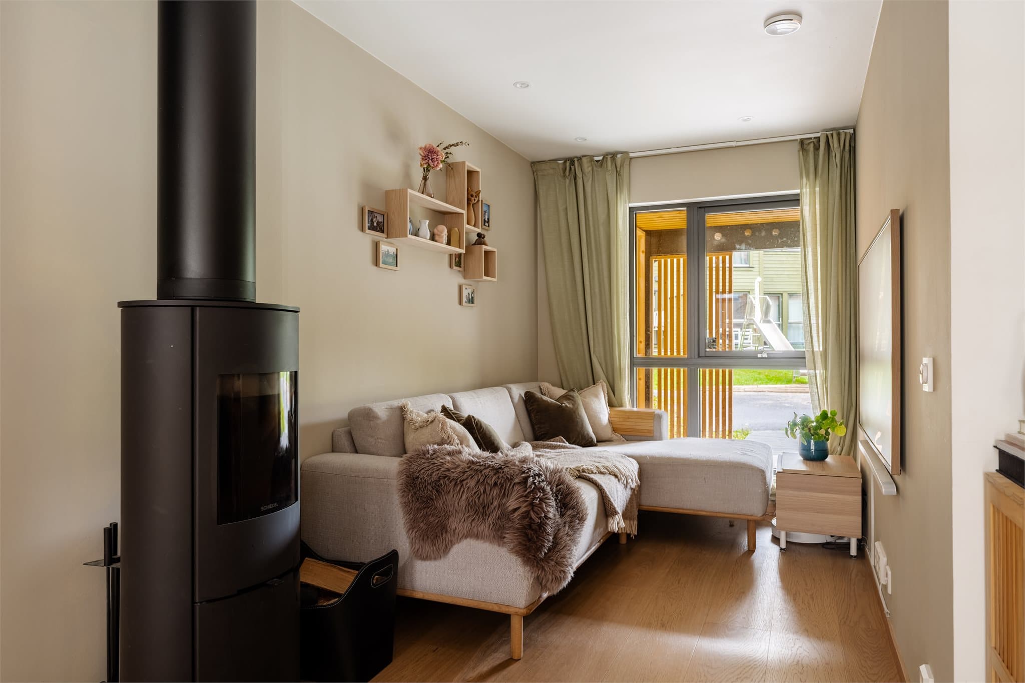 Stuen har en lun atmosfære med peisovn som bidrar til både varme og hygge.