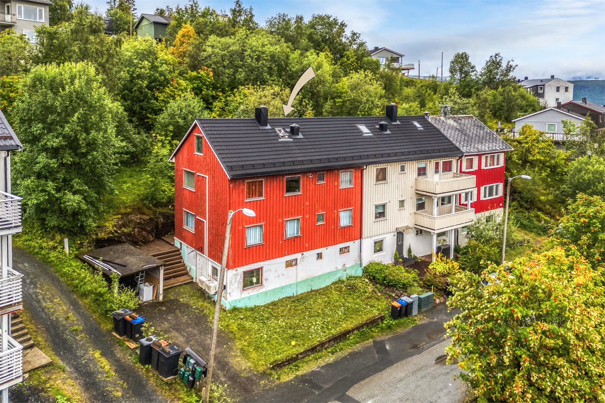 Eiendommen ligger i et etablert boligstrøk omgitt av frodig vegetasjon.