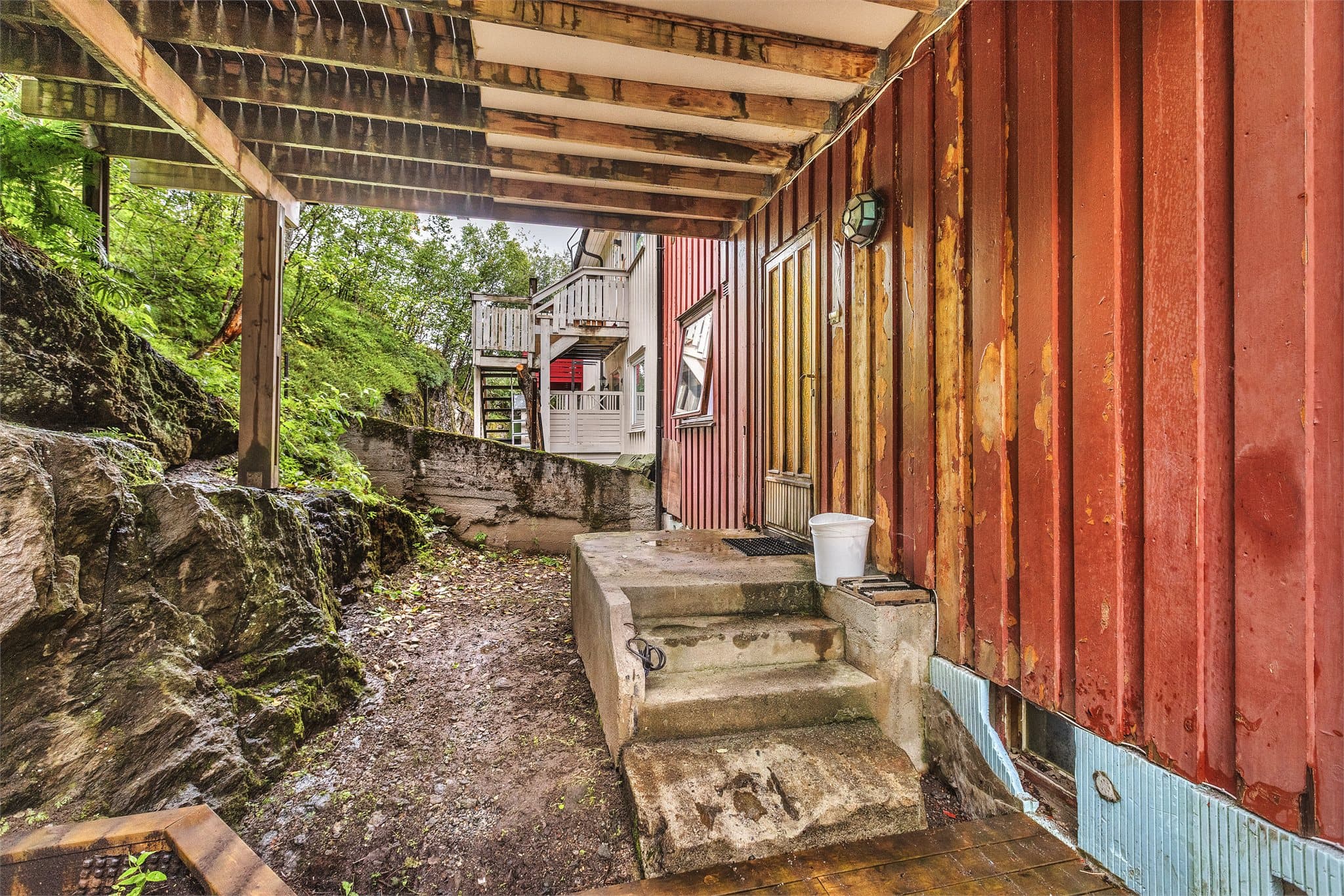 Inngangsparti og trappeløp på baksiden av boligen i tilknytning til fjellet.