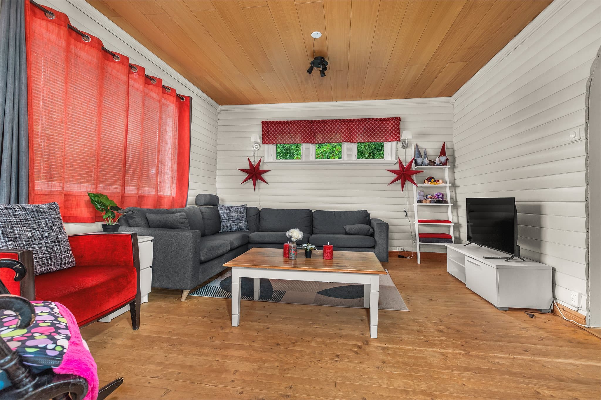 Stuen i andre etasje har panelkledde overflater og rikelig med plass til sofagruppe.