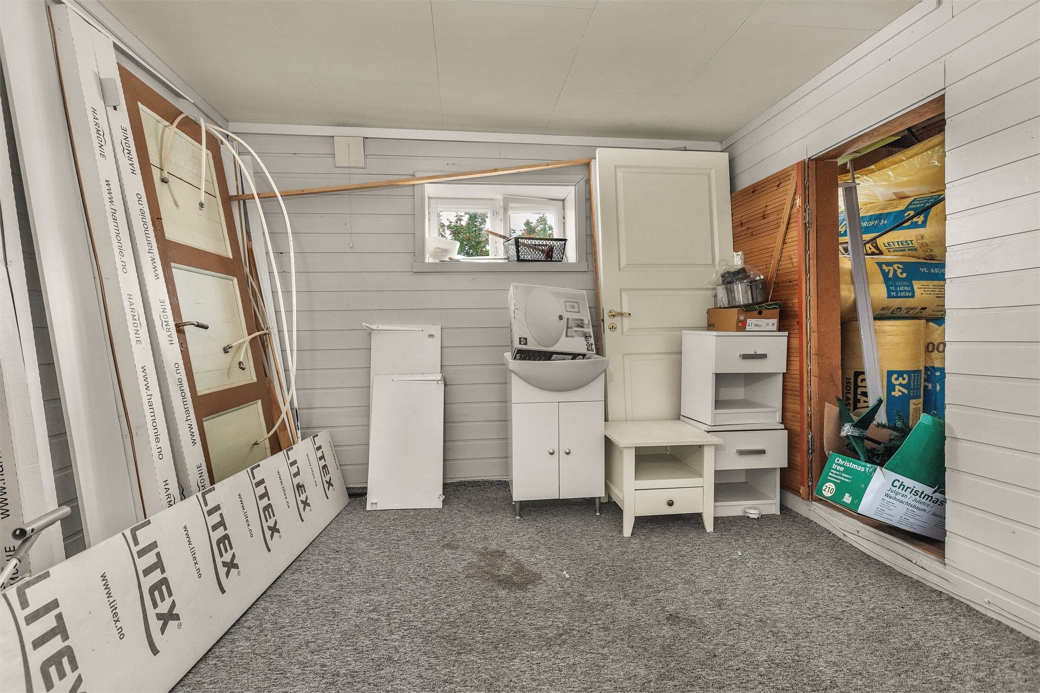 Romslig kjellerrom med oppbevaringsmuligheter og materialer for videre arbeid.