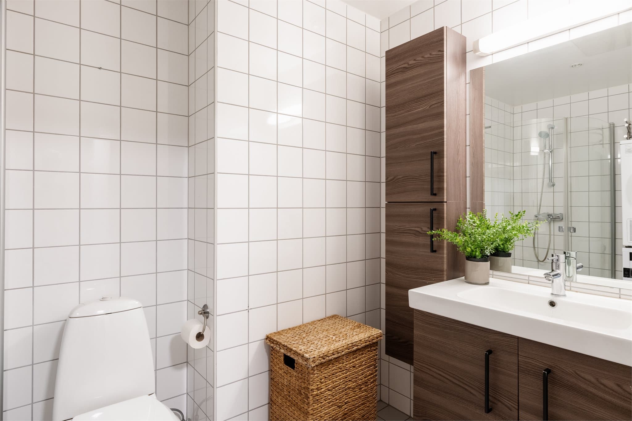 Badet er innredet med servant, speilskap og har opplegg for vaskemaskin.