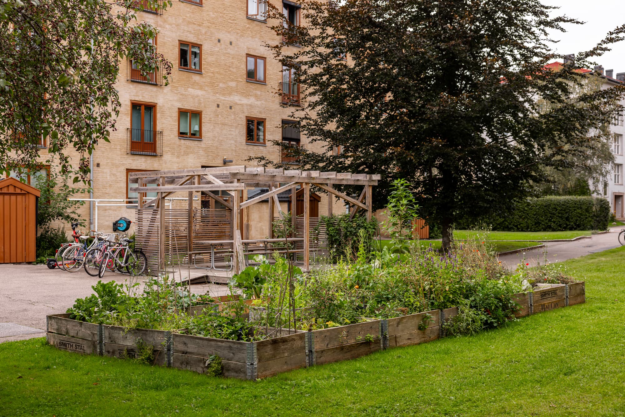 Innbydende utearealer med sitteplasser, beplantning og mulighet for hyggelige grillkvelder under pergola.