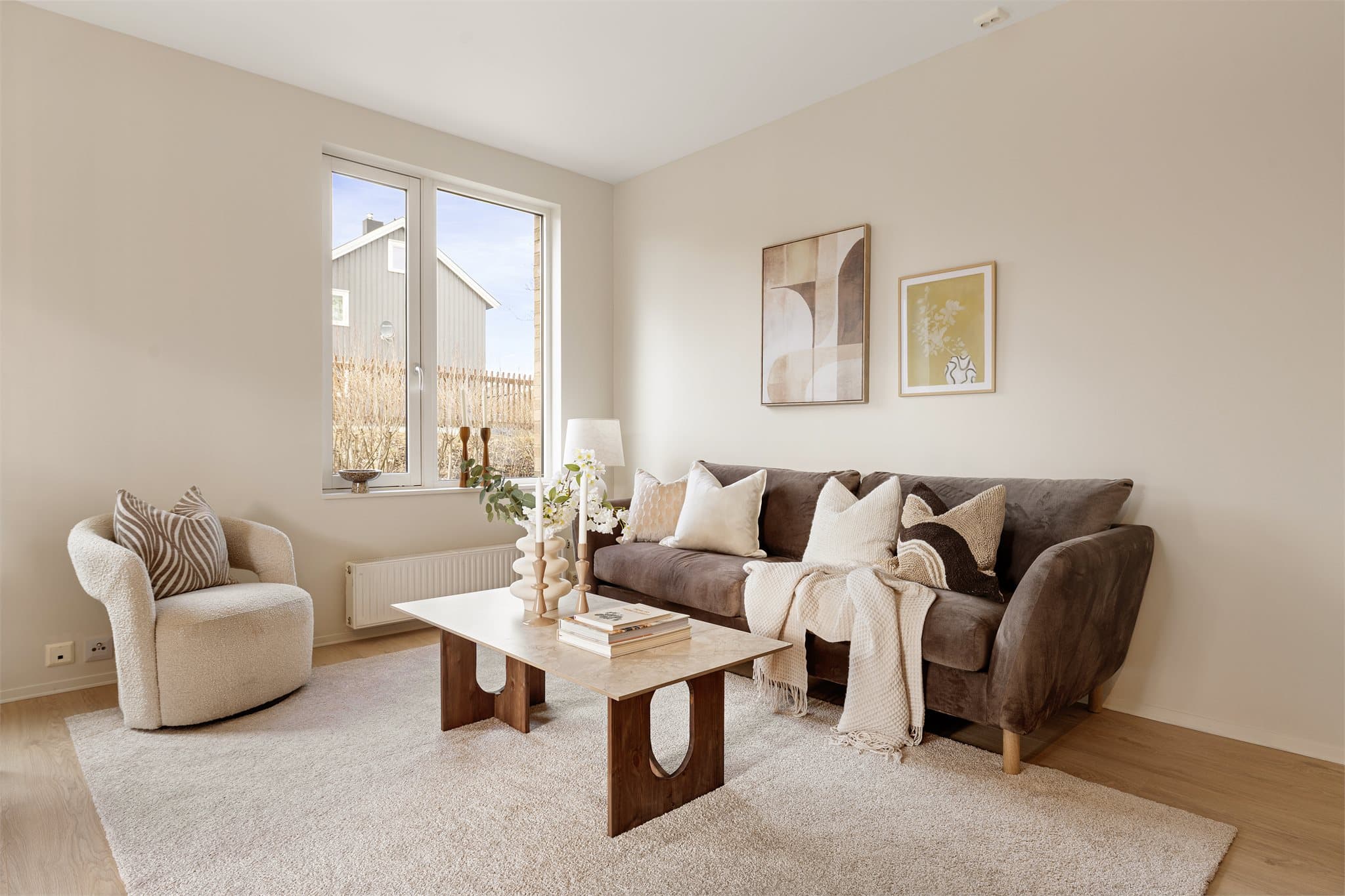 Leiligheten fremstår delikat og innbydende med listefrie tak og vinduer, og lune farger som gir en behagelig atmosfære.