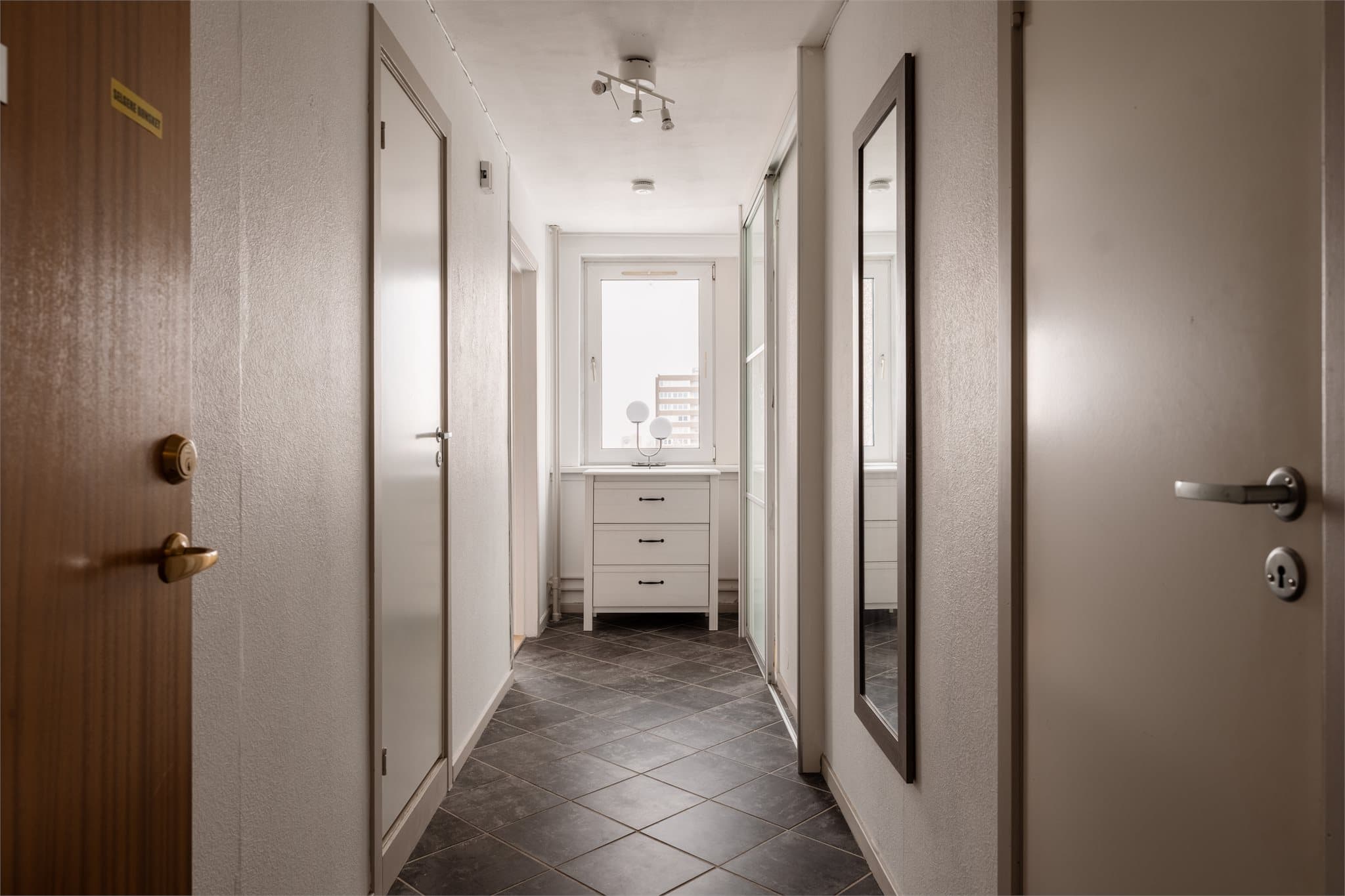 Flislagt entré med adkomst til alle boligens rom. En funksjonell og ryddig velkomstsone.