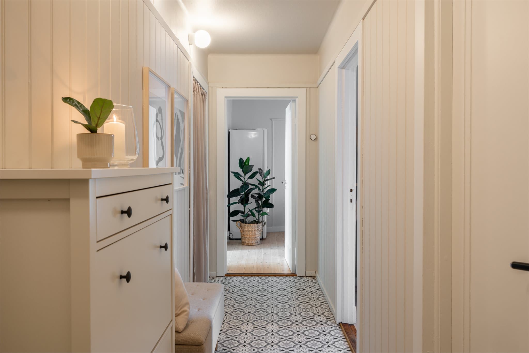 Den klassiske entréen gir et godt førsteinntrykk med mønstrede gulvfliser og lyse panelvegger.