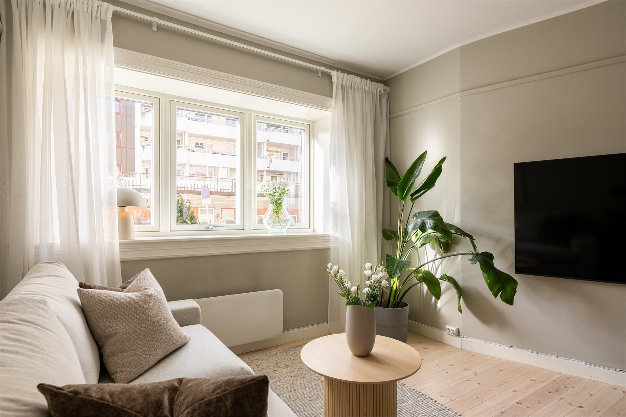 Gjennomgående tregulv og en lys fargepalett danner et nøytralt og behagelig utgangspunkt. Store vindusflater gir rikelig med naturlig lys og en luftig atmosfære.