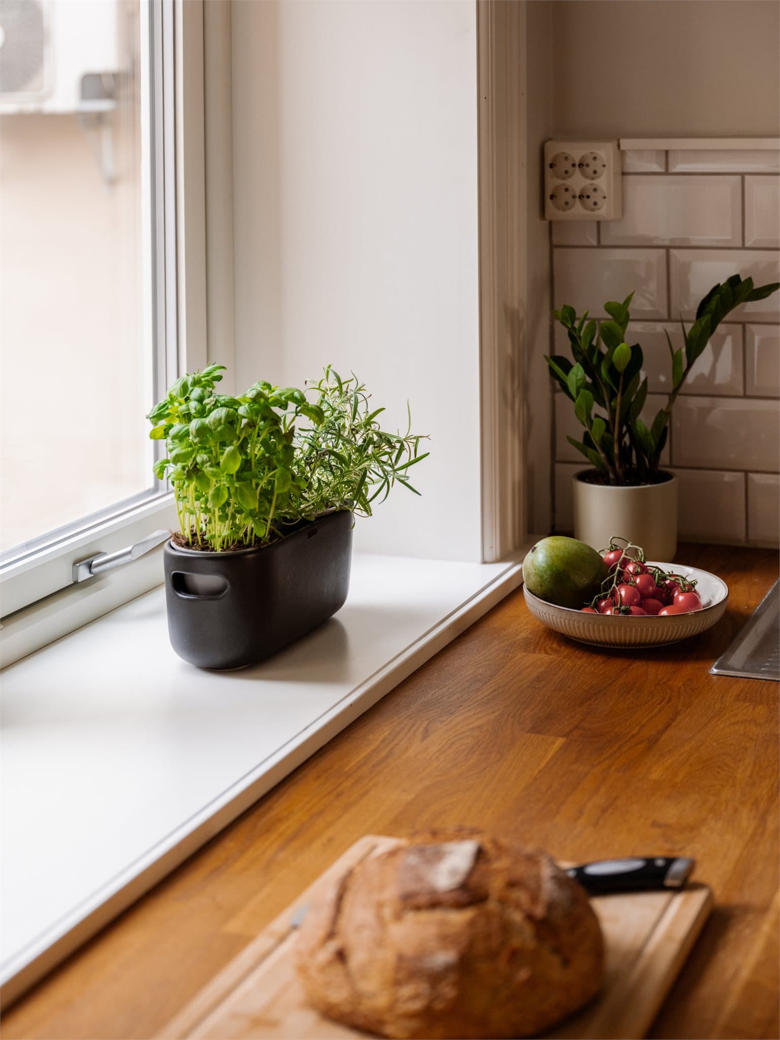 En bred vinduskarm gir plass til urter og skaper en hyggelig atmosfære.