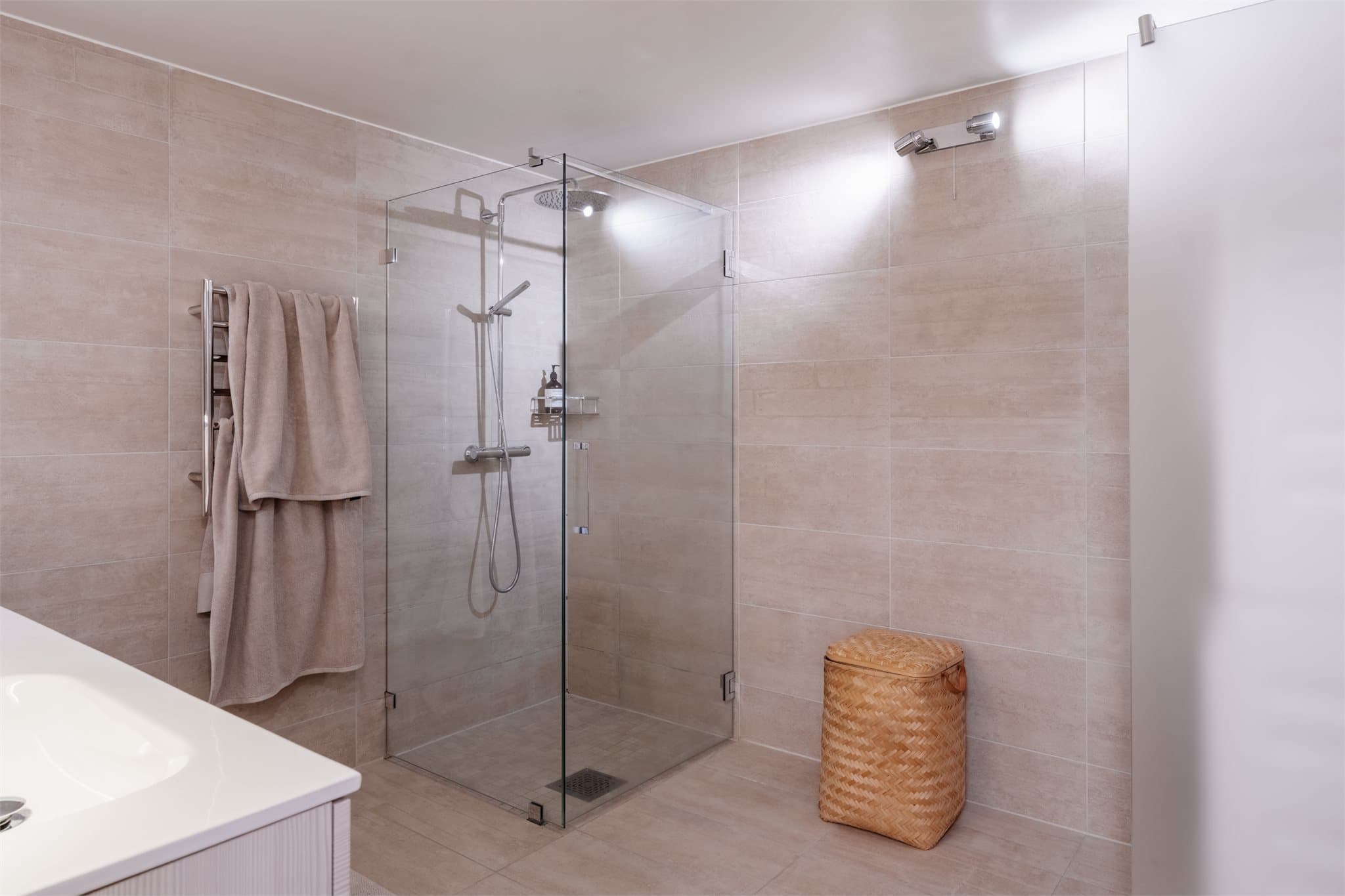 Badet er innredet med dobbel servant med ettgreps blandebatterier og underskap som gir god oppbevaringsplass. Dusjsonen har foldbare glassdører.