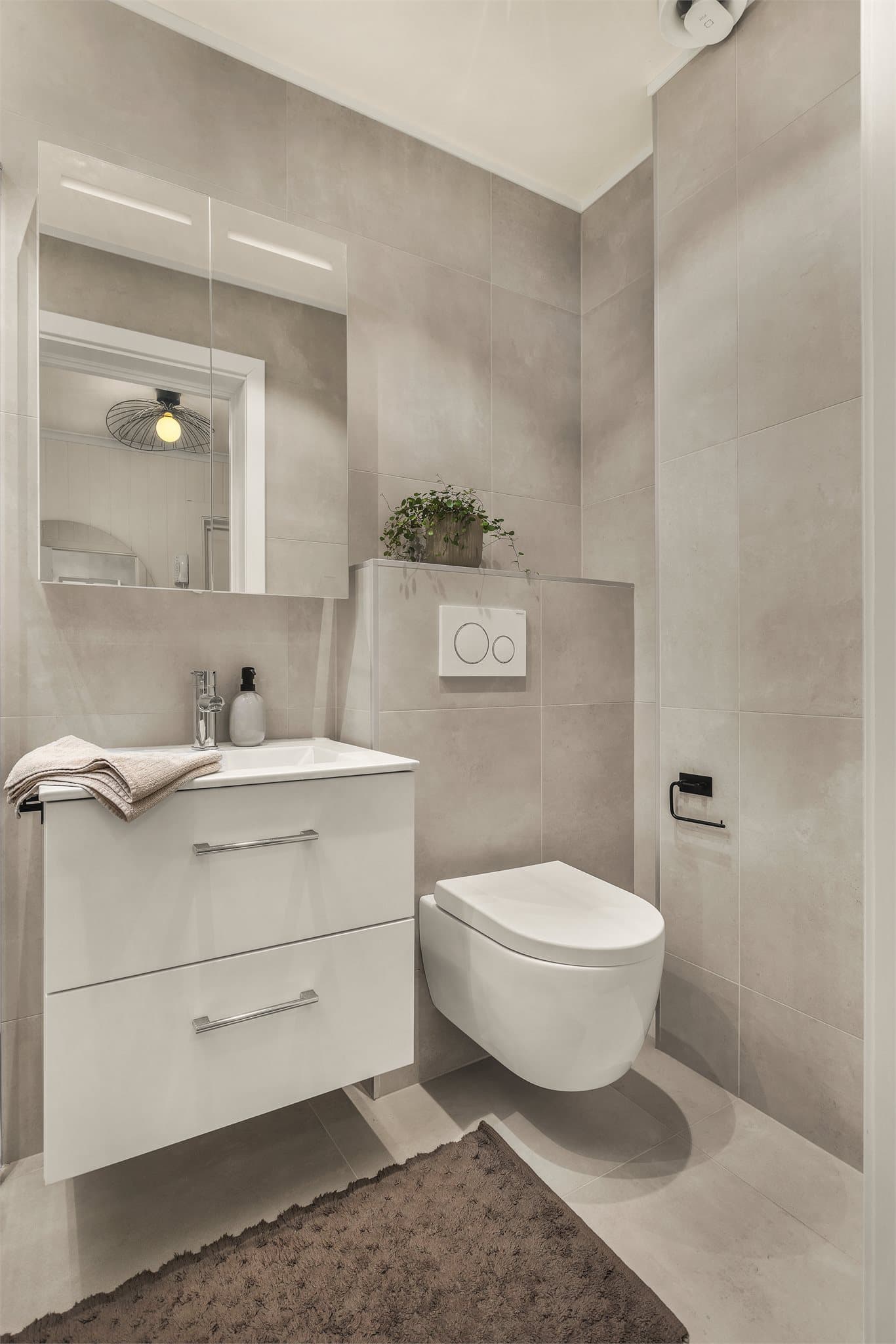 Her er det vegghengt toalett, dusjnisje og servant