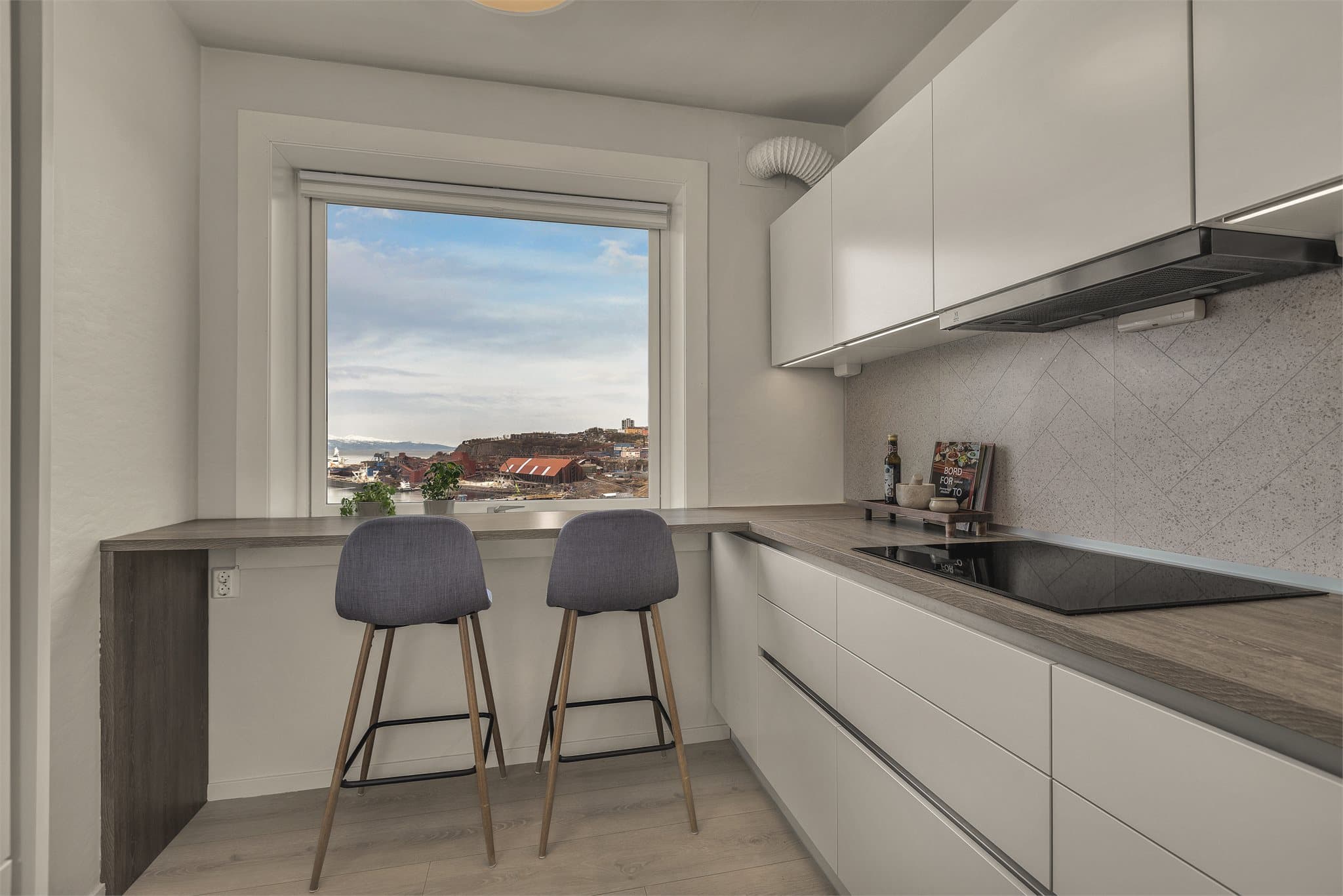 Kjøkkeninnredning fra 2022 med praktisk barbord hvor du kan nyte frokosten til en fantastisk utsikt!