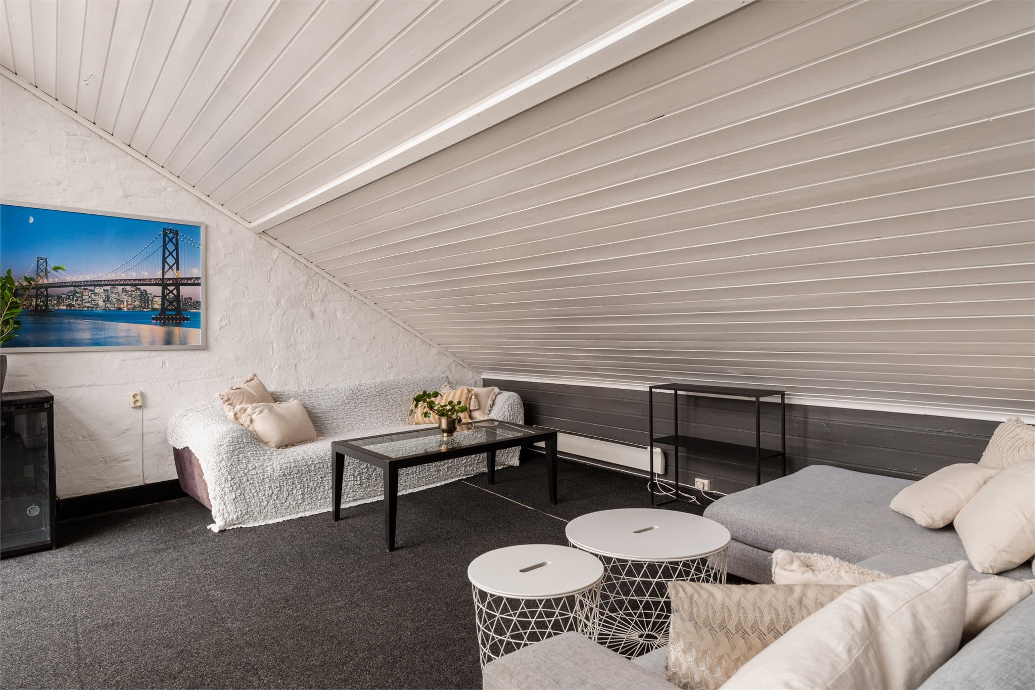 Lys og romslig oppholdsrom med mange sitteplasser.