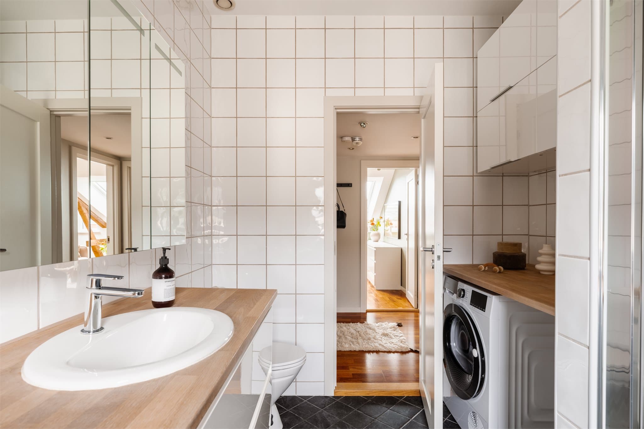 Badet byr på mye oppbevaringsplass og opplegg for vaskemaskin under benkeplaten.