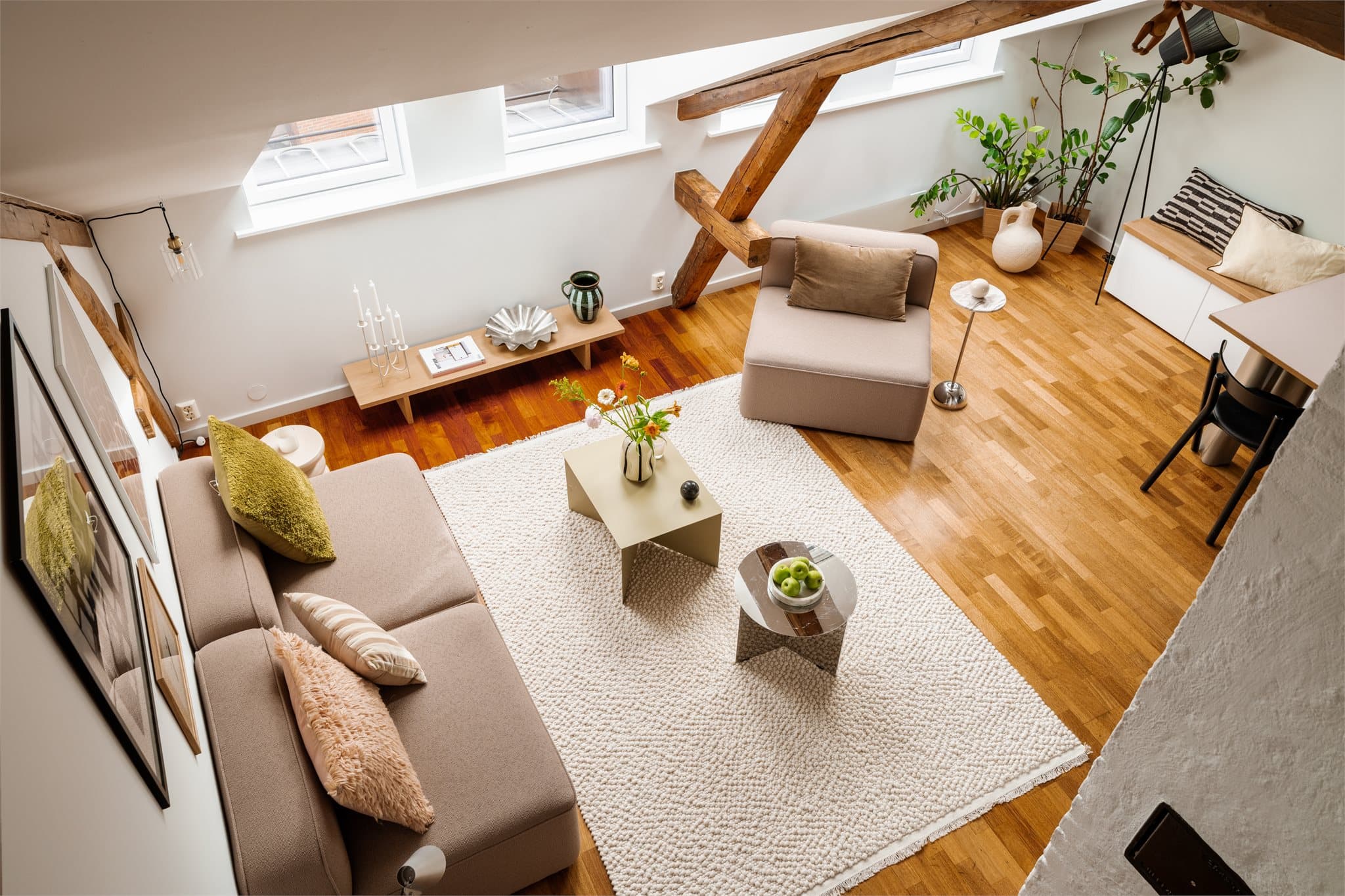 Fra hemsen har man utsyn ned til stuen i hovedetasjen, noe som understreker den åpne og luftige romfølelsen.