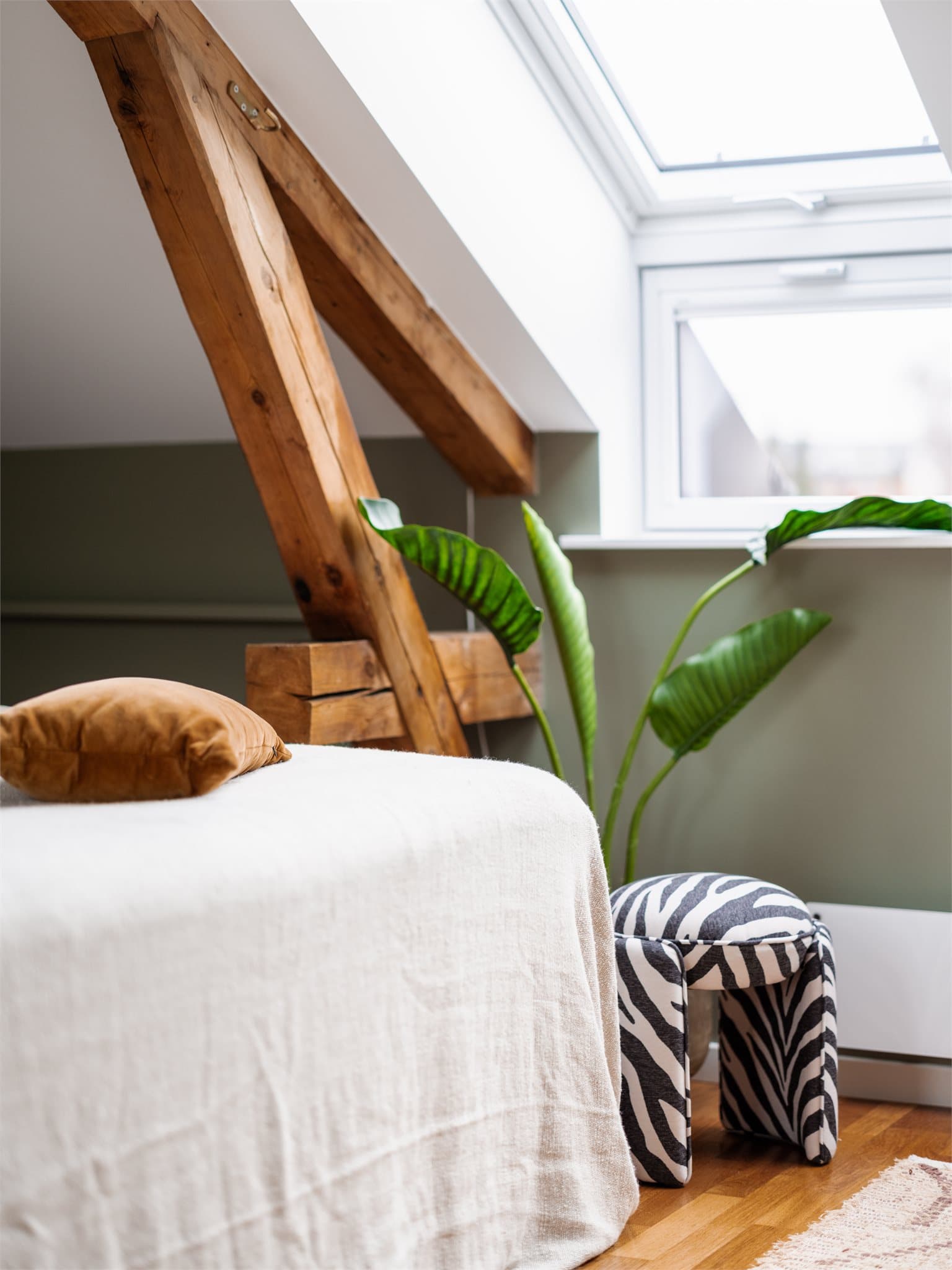 Synlige takbjelker går igjen i flere av rommene og gir leiligheten et gjennomgående og helhetlig preg.