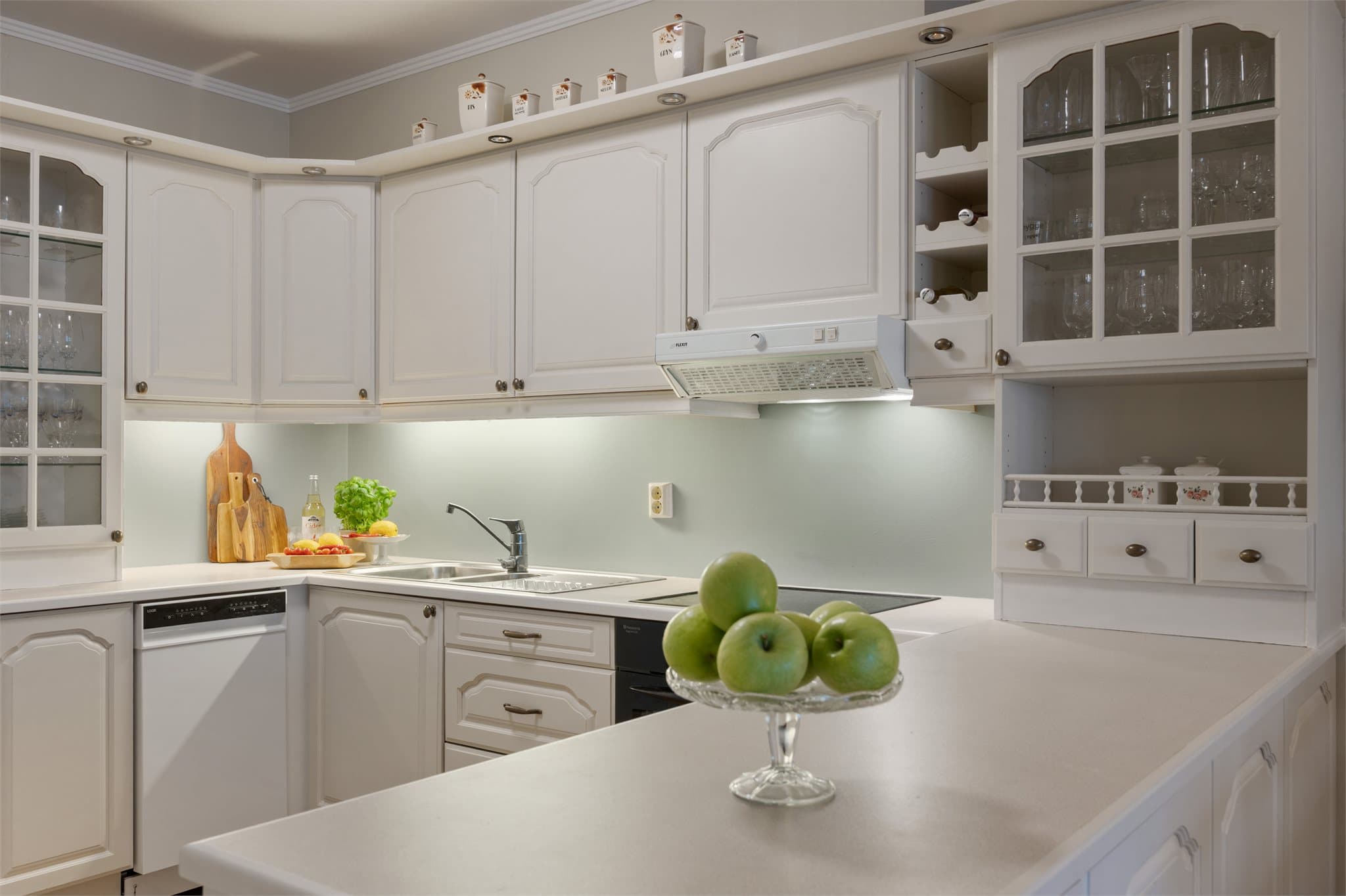 Kjøkkenet er utformet i en praktisk U-løsning med rikelig benkeplass og gode arbeidsflater, som gjør matlagingen både effektiv og trivelig.