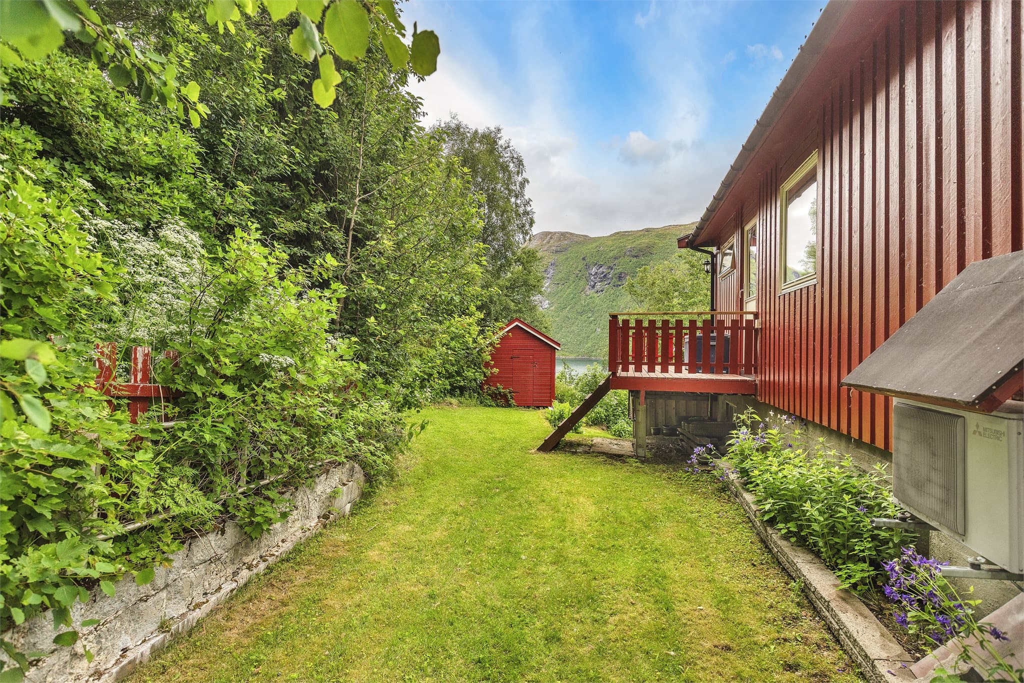 Tomten er avgrenset av støttemurer i betongstein.
