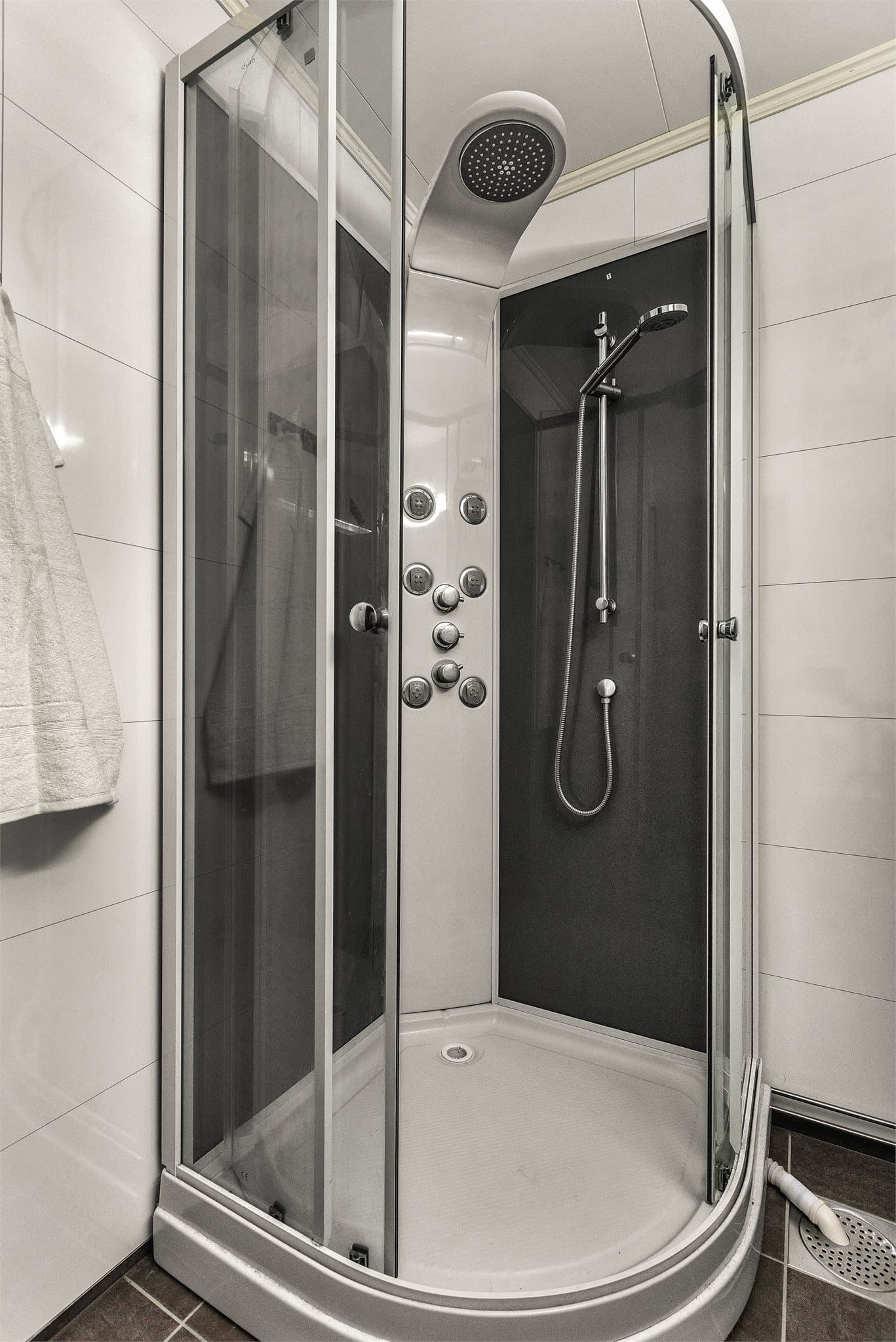 Badet har flislagt gulv med elektriske varmekabler og dusjkabinett.
