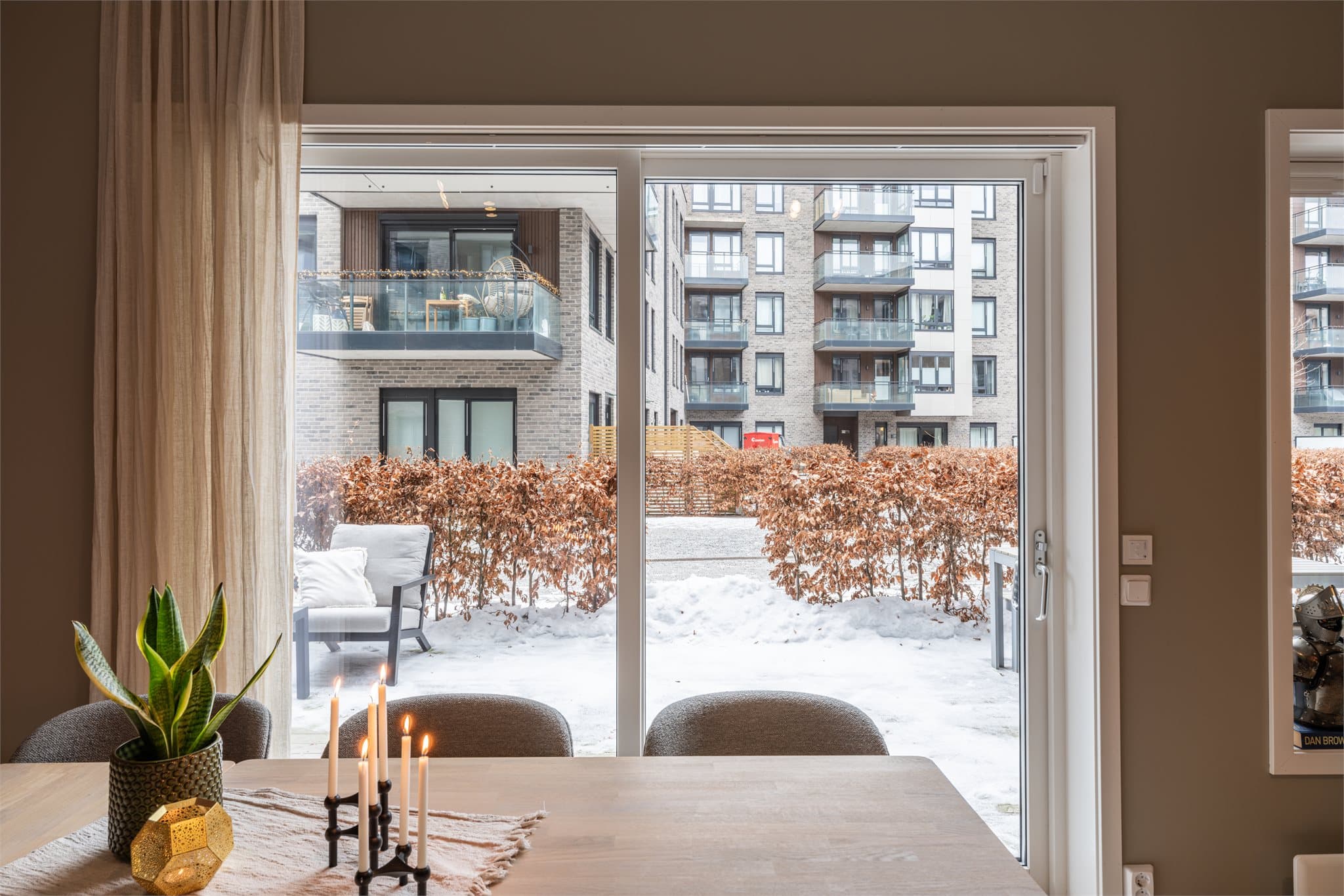 Den store skyvedøren gir rikelig med naturlig lys og skaper en sømløs overgang til markterrassen. Skyvedøren er utstyrt med screens for effektiv solskjerming.