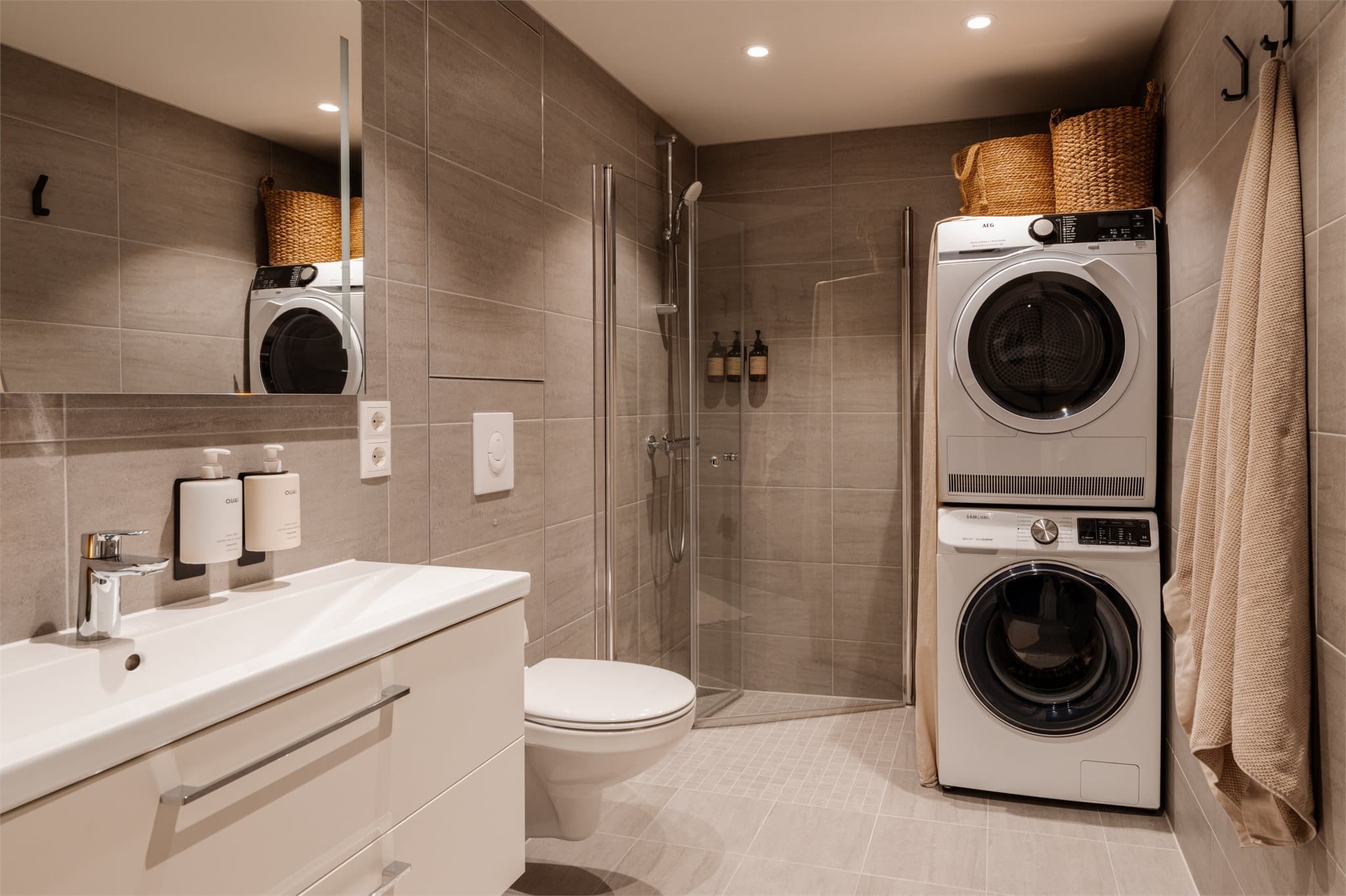 Leilighetens baderom er flislagt i en lun fargepalett og det er selvsagt varme i gulvet.