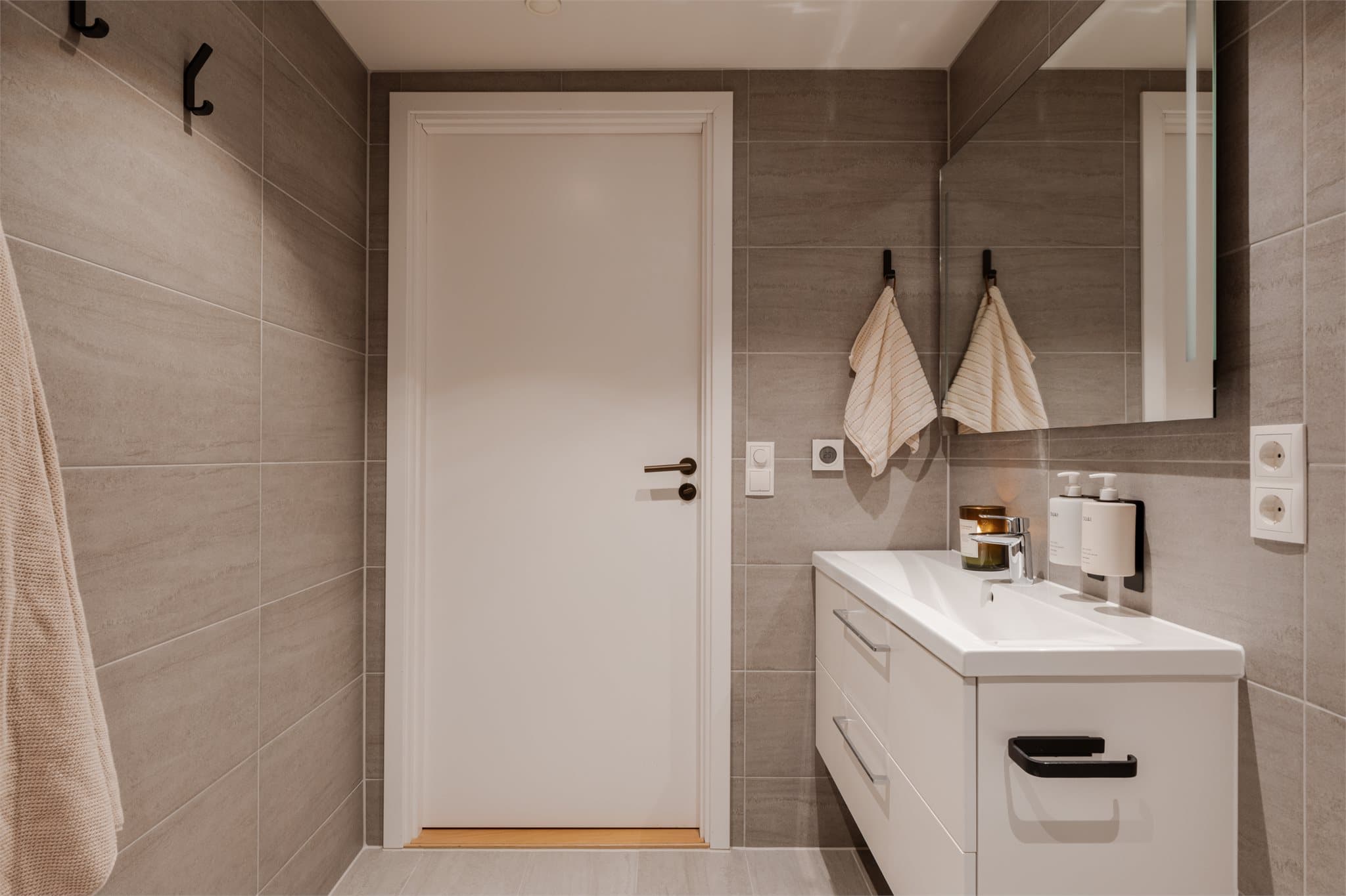 Baderomsinnredningen er holdt i lyse farger og det er innfelte downlights i himlingen.