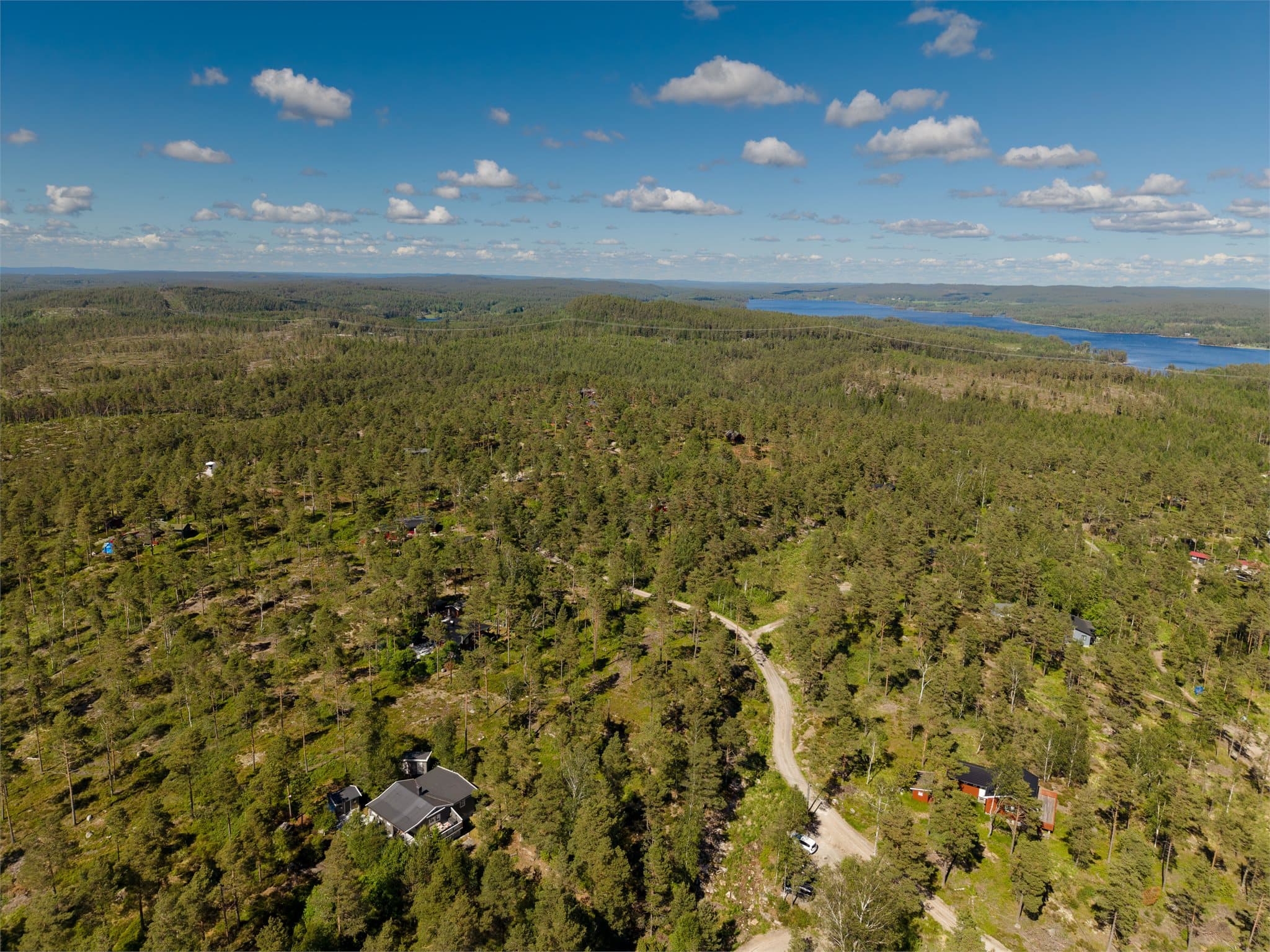 Hytta (nede til venstre) med omkringliggende hytter og natur.