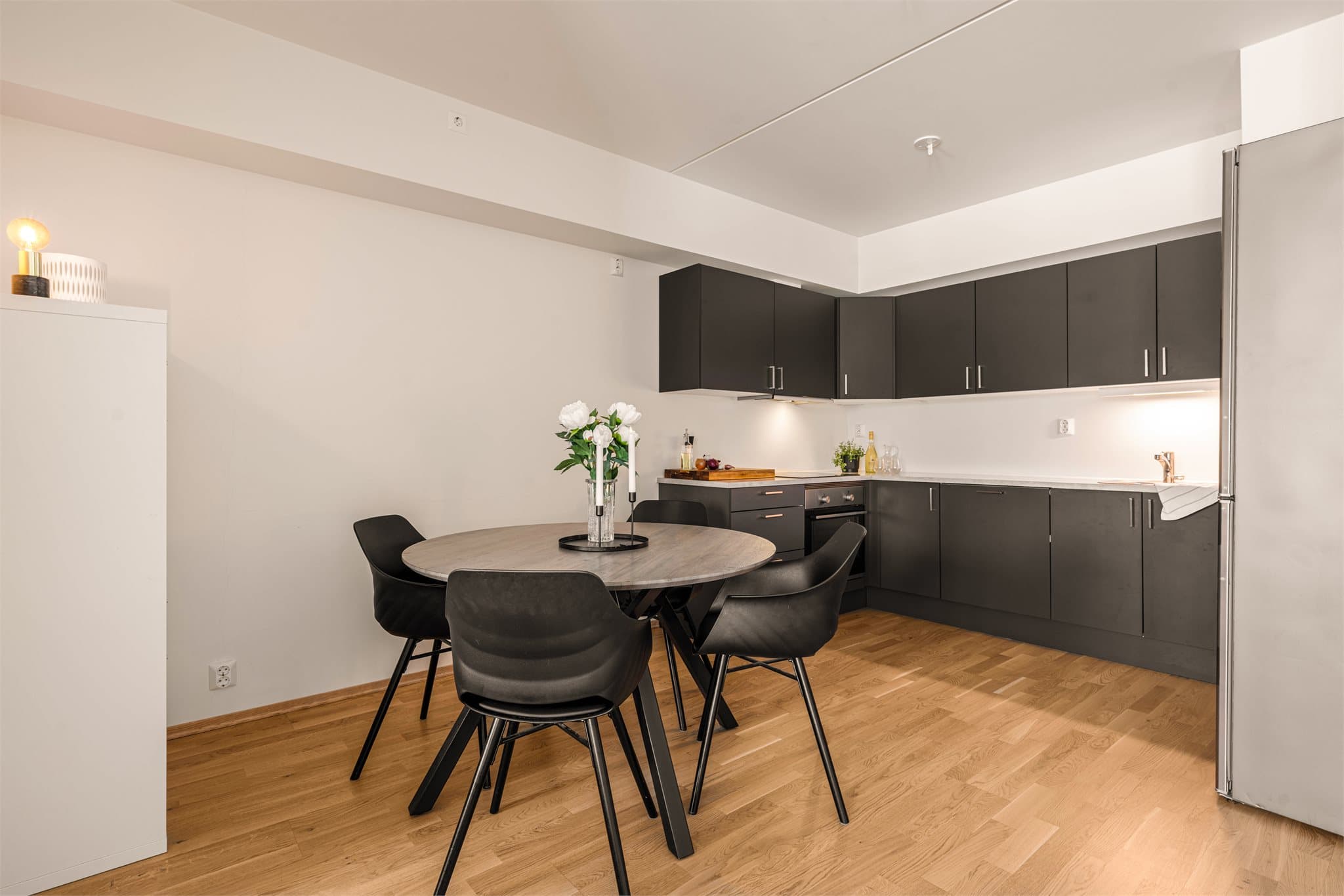 Kjøkken er tilbaketrukket i eget hjørne med god plass til stort spisebord i forkant.