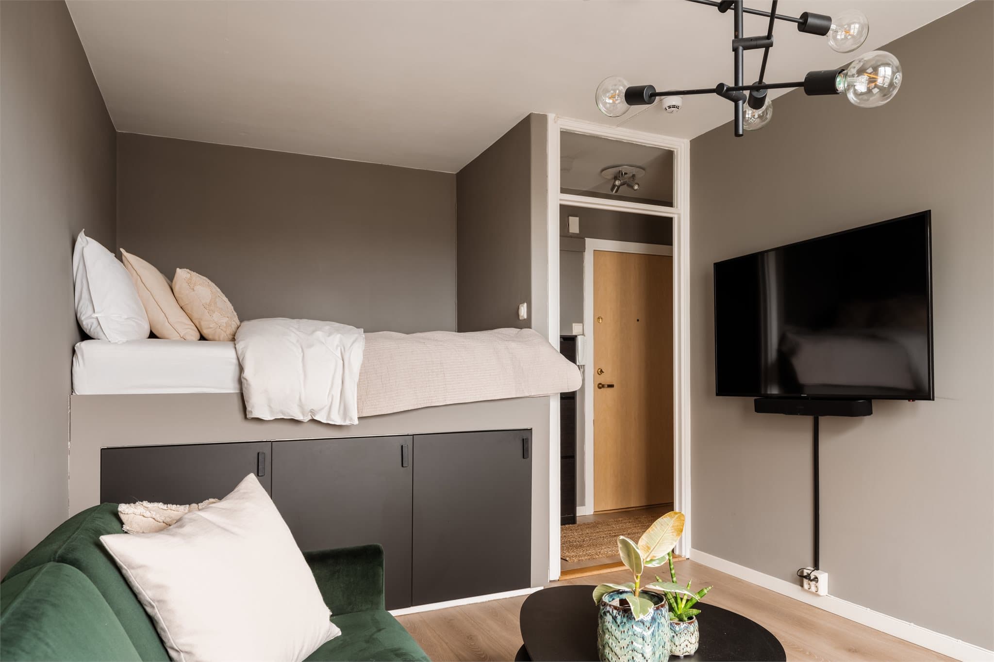 Løsningen kombinerer sove- og oppholdsrom på en arealeffektiv måte.