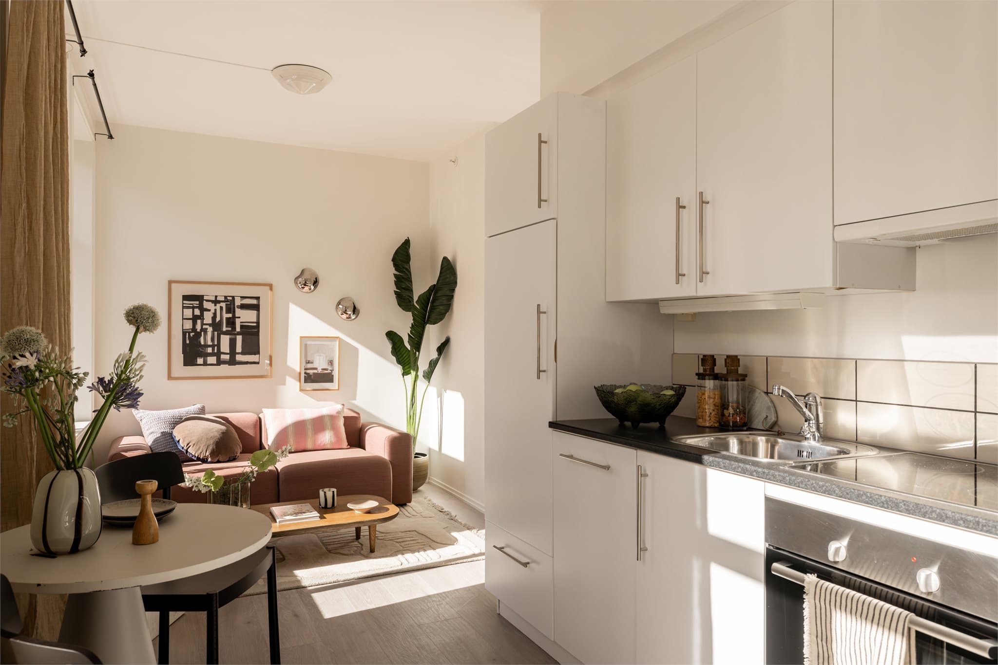 Et lyst kjøkken med integrerte hvitevarer og god benke- og skapplass.