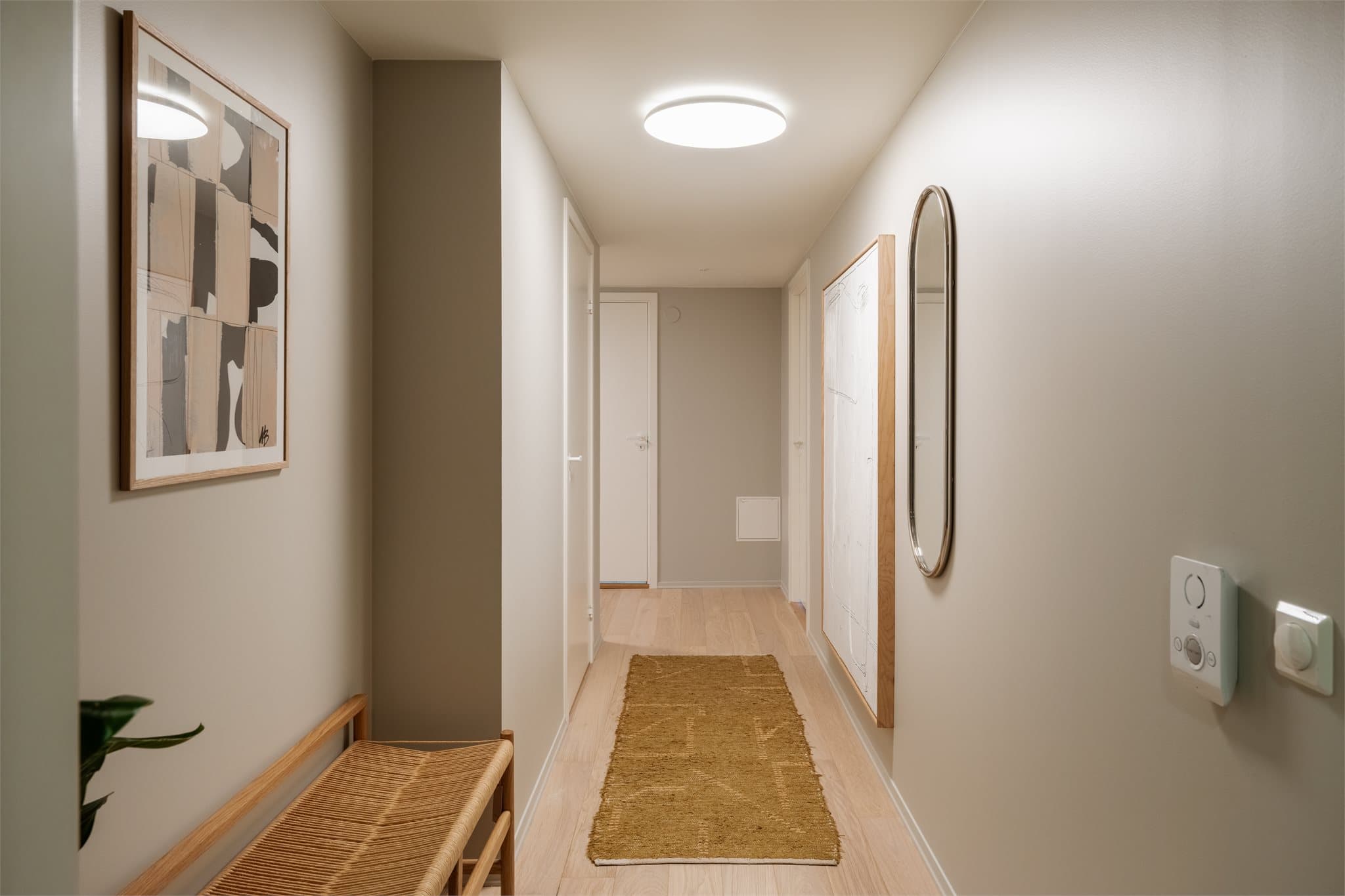 Innbydende entré med et ryddig og stilrent førsteinntrykk. Gangen har gode oppbevaringsmuligheter og plass til yttertøy og sko, samtidig som den lyse fargepaletten og de rene linjene gir en luftig følelse.