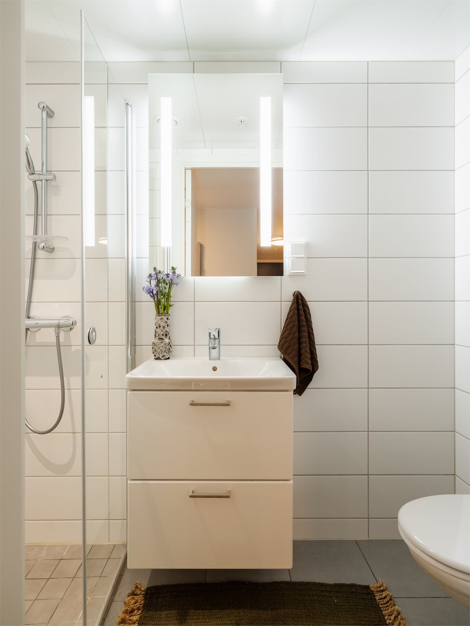 Boligen har et praktisk baderom nummer to med flislagte overflater og behagelig vannbåren gulvvarme.