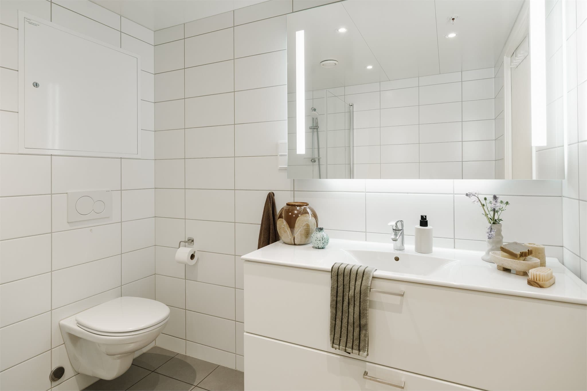 Rikelig med plass til oppbevaring i romslig baderomsinnredning.